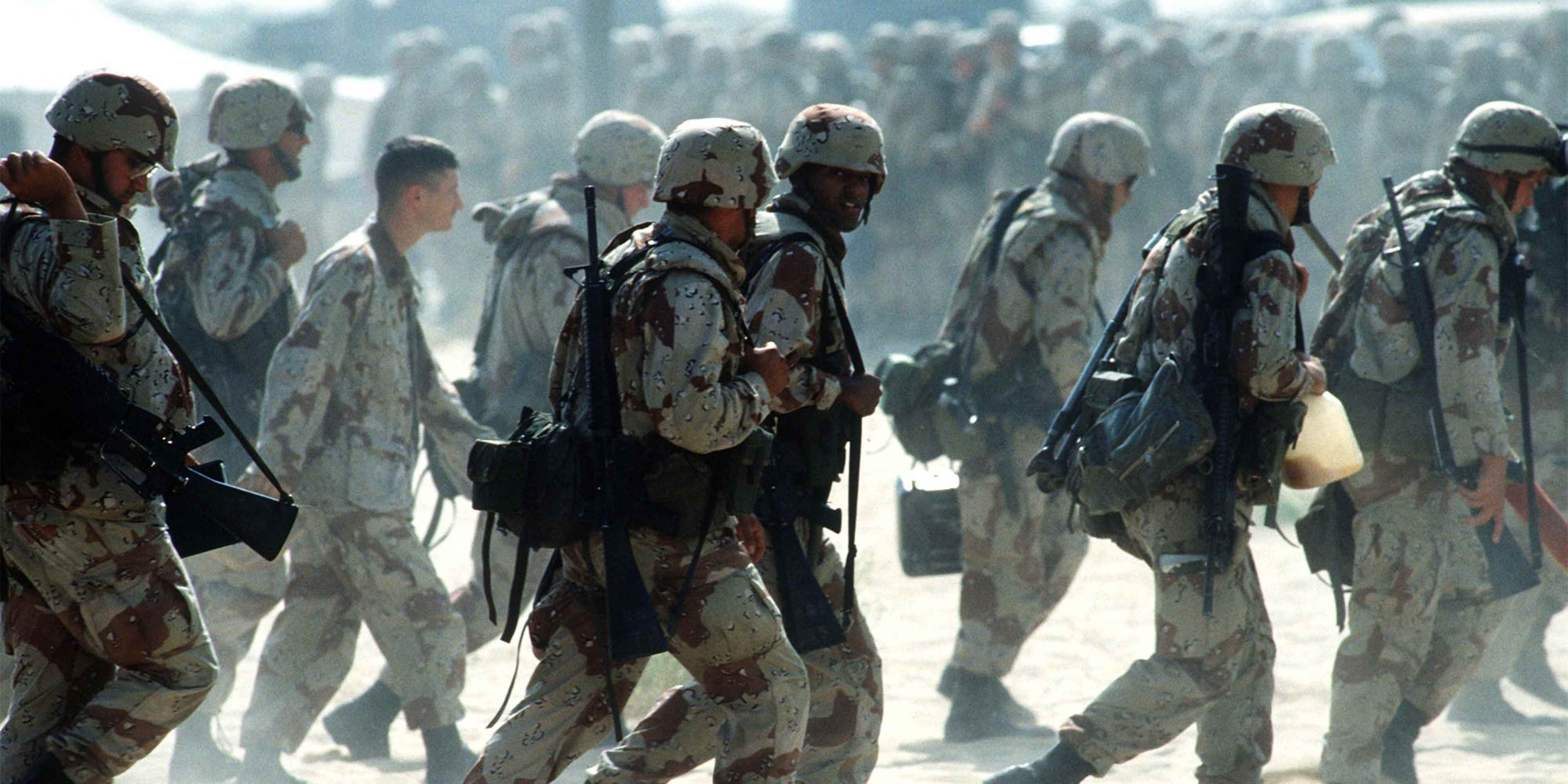 Newly arrived Marines are led through an encampment near an airfield during the Persian Gulf War's Operation Desert Shield.