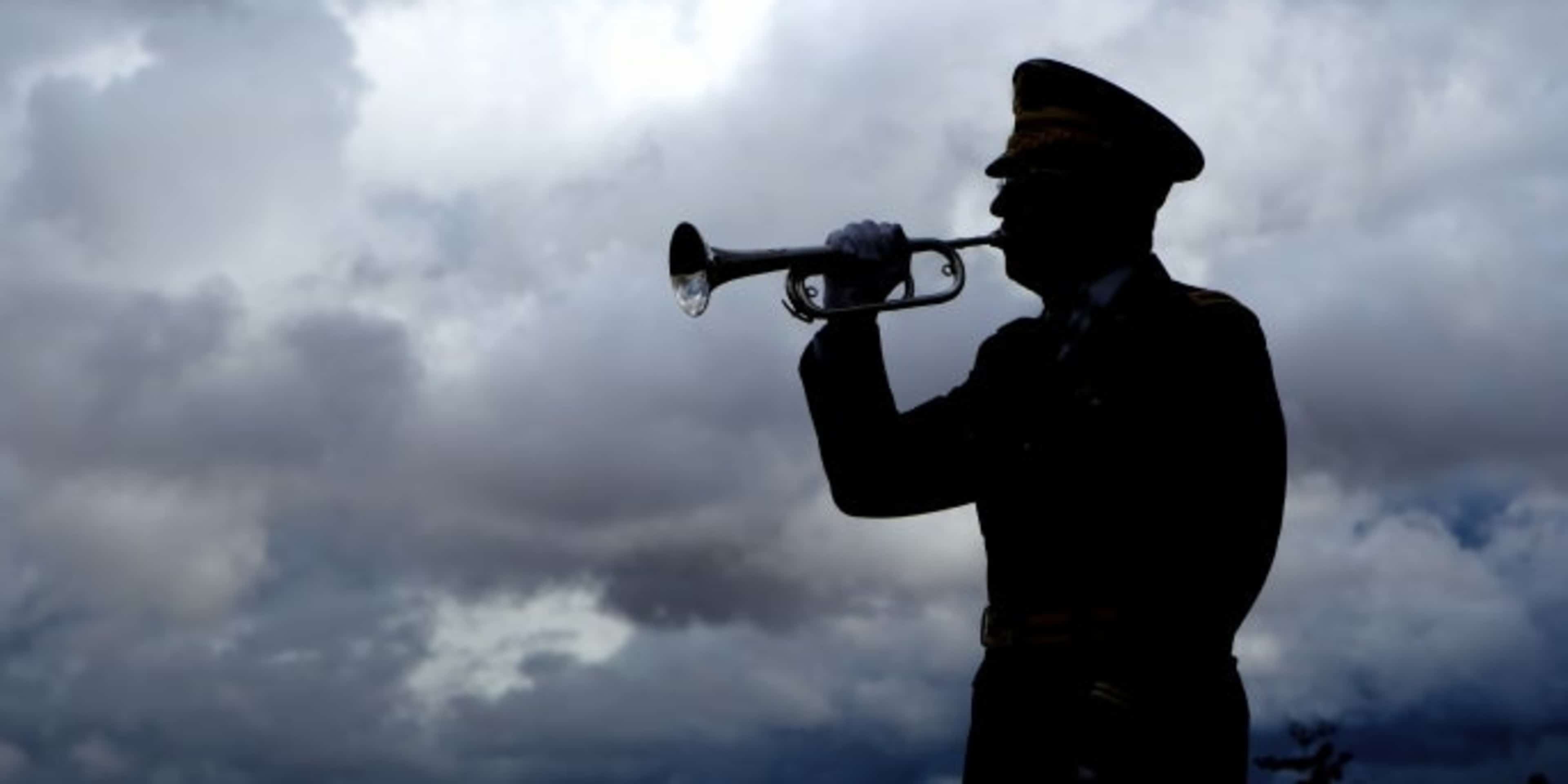Silhouette of a man playing taps on his bugle. (Credit: gjohnstonphoto/istockphoto.com)