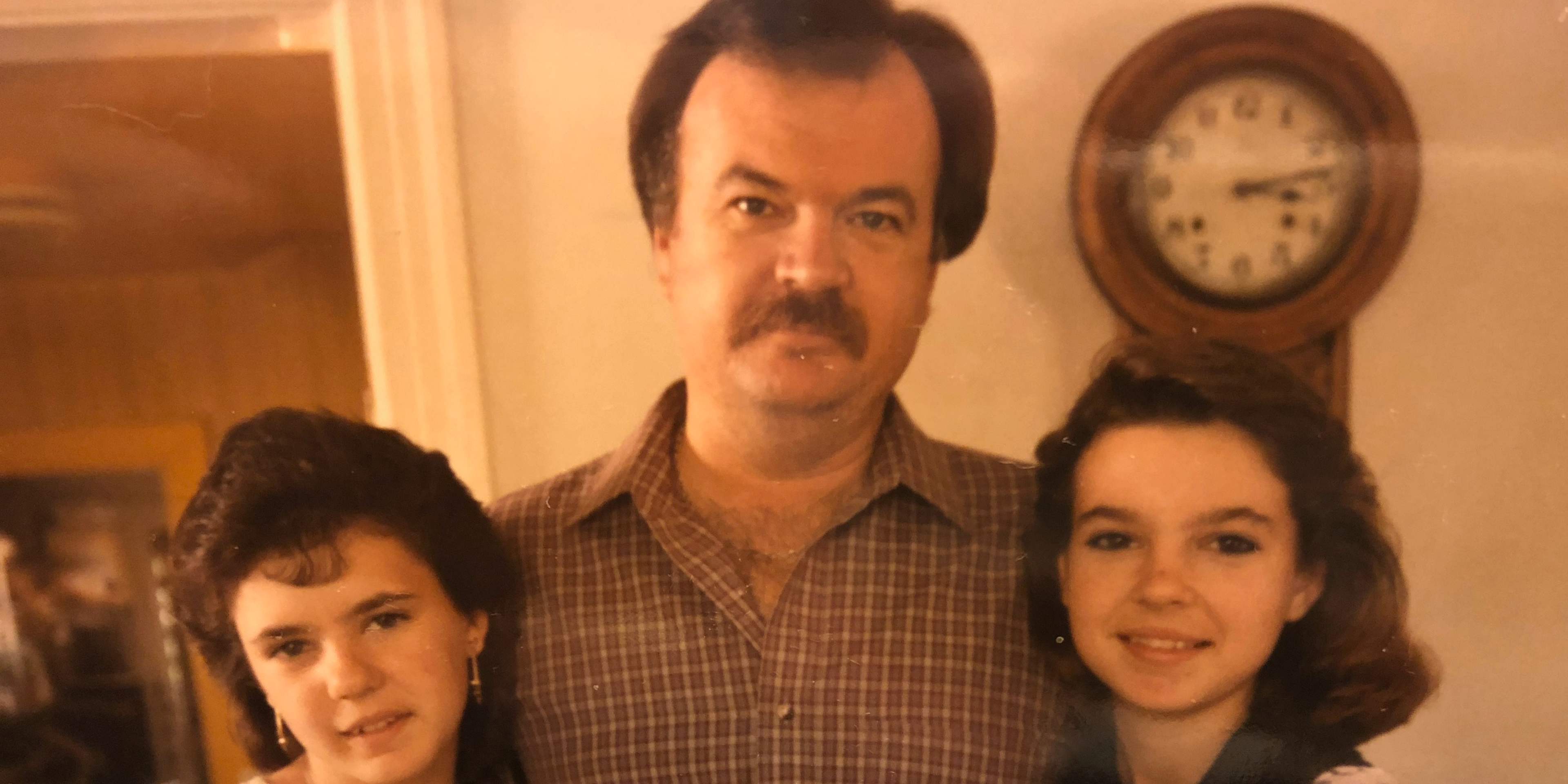 The image shows a family portrait of a man with a mustache, a woman with dark hair, and a young girl, all smiling and posing together in what appears to be a living room setting with a clock on the wall.