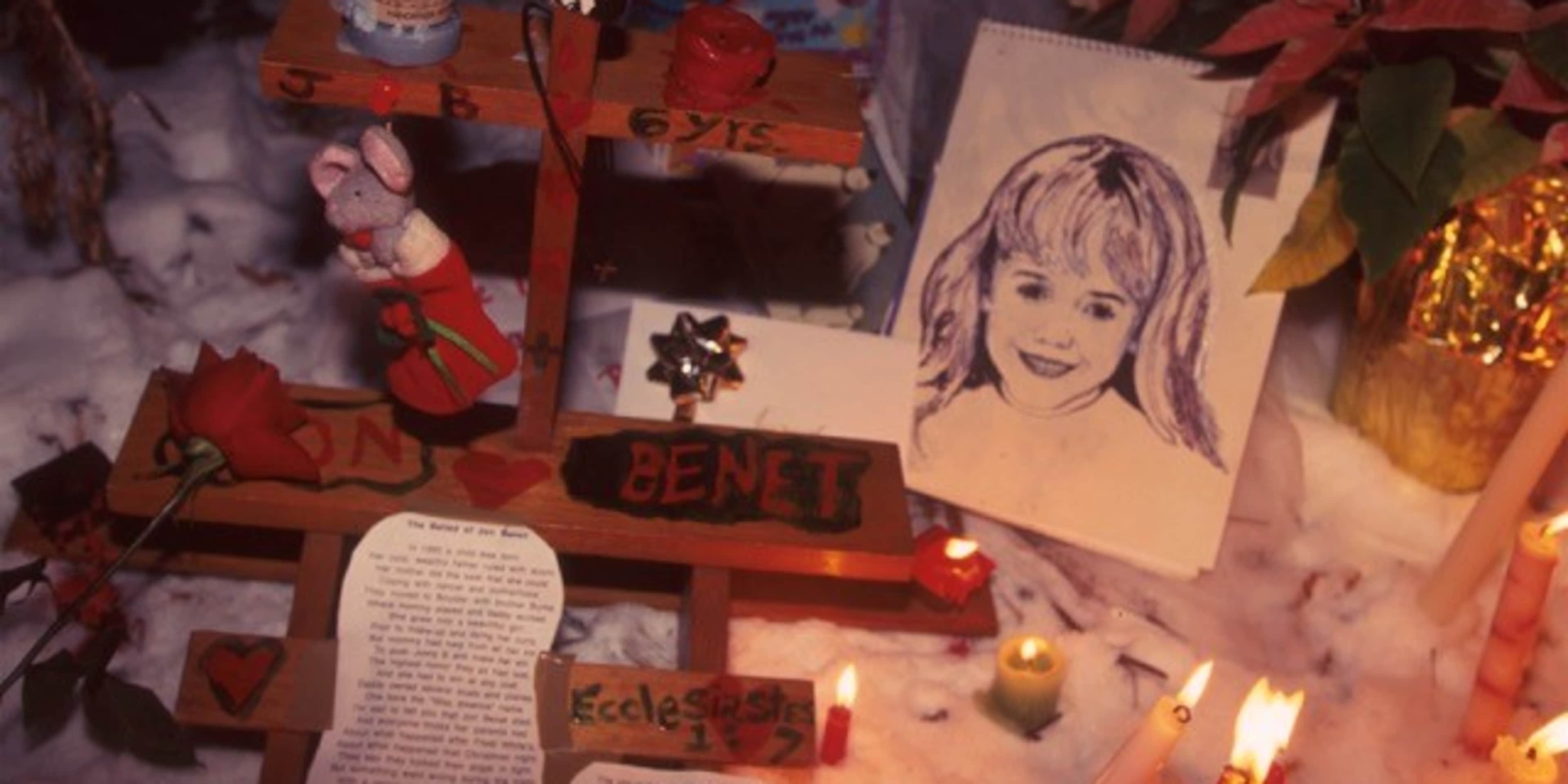 A collection of various items, including a portrait, candles, and other decorative elements, arranged in a dimly lit setting.