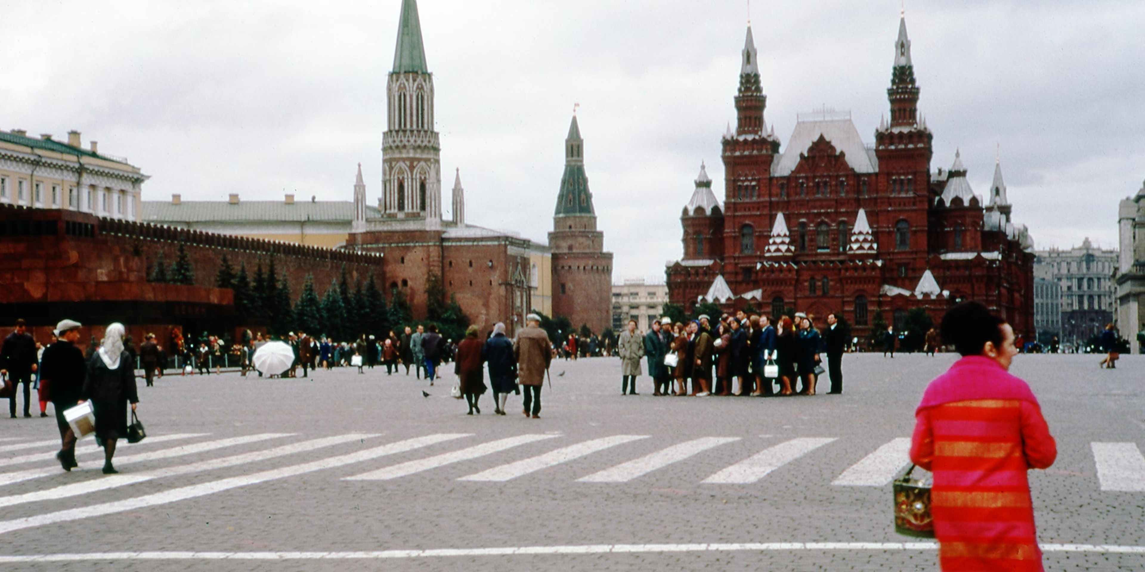 A woman in a bright coat walks among the crowds in Red Square near the State Historical Museum, in Moscow, Russia, 1973.