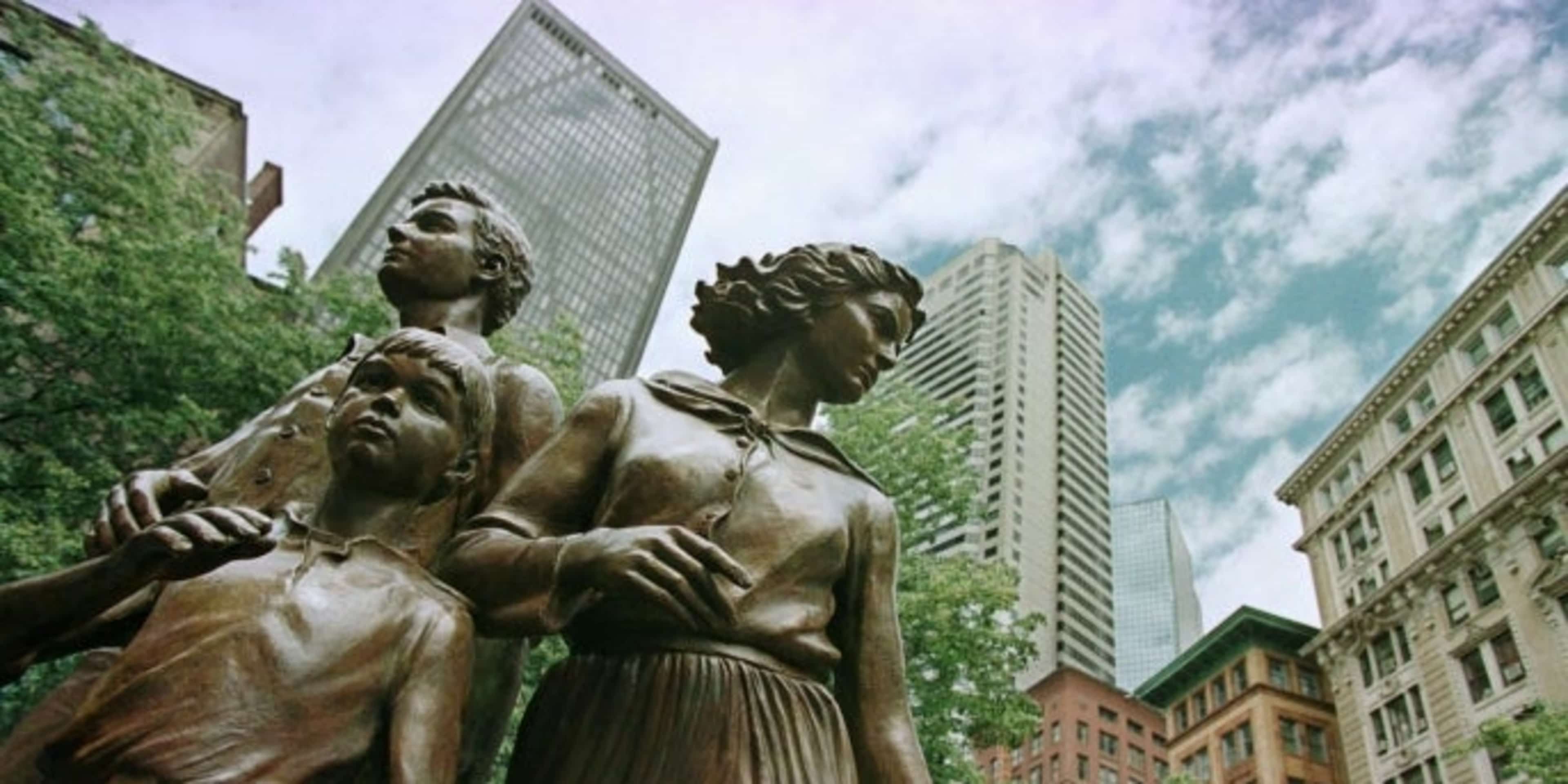 Statues created by artist Robert Shure depicting a hopeful Irish family landing in Boston as part of the Irish Famine Memorial. (Credit: Victoria Arocho/AP Photo)