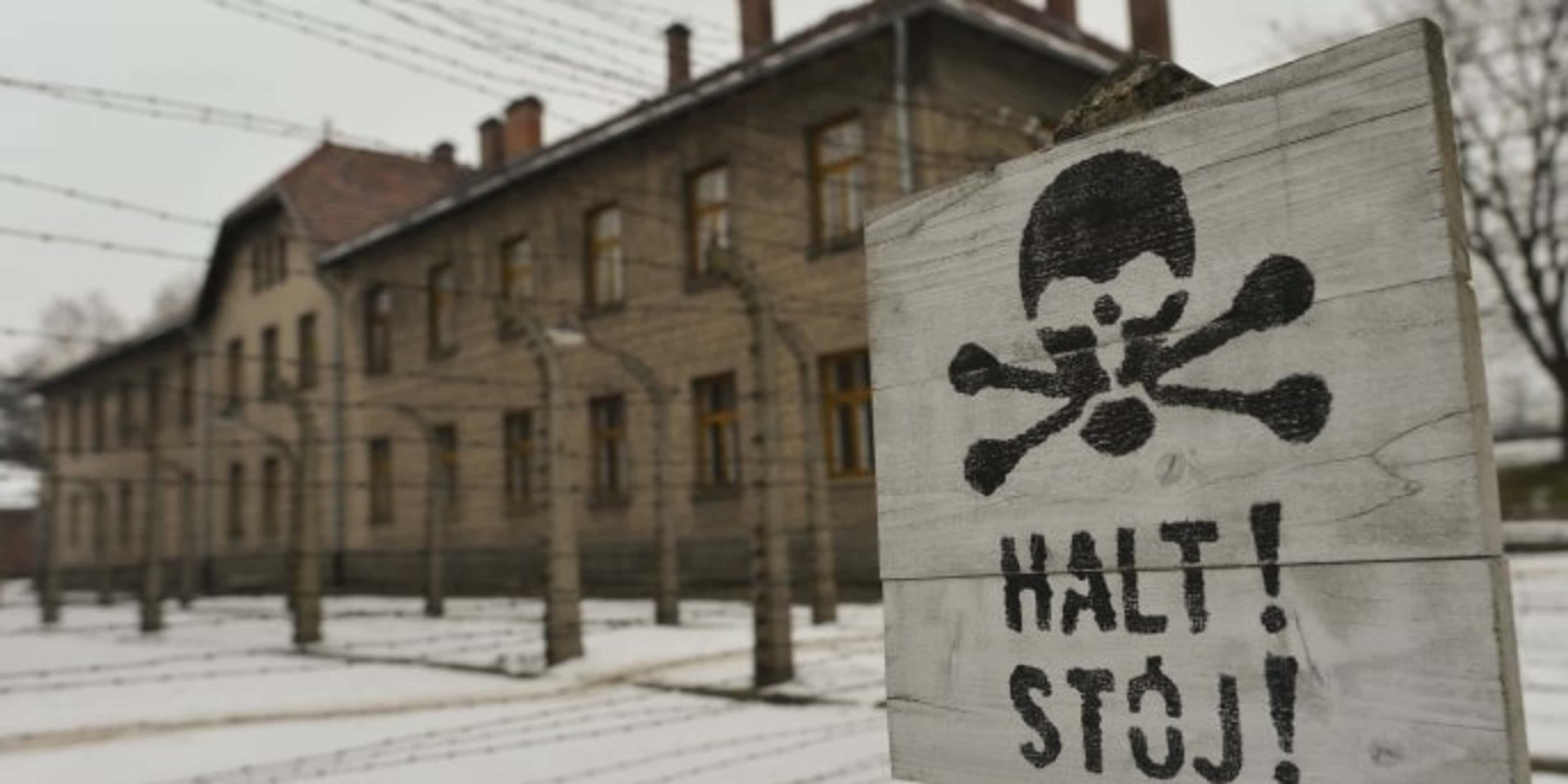 A warning sign near the entrance to the former Auschwitz camp. (Credit: Artur Widak/NurPhoto/Getty Images)