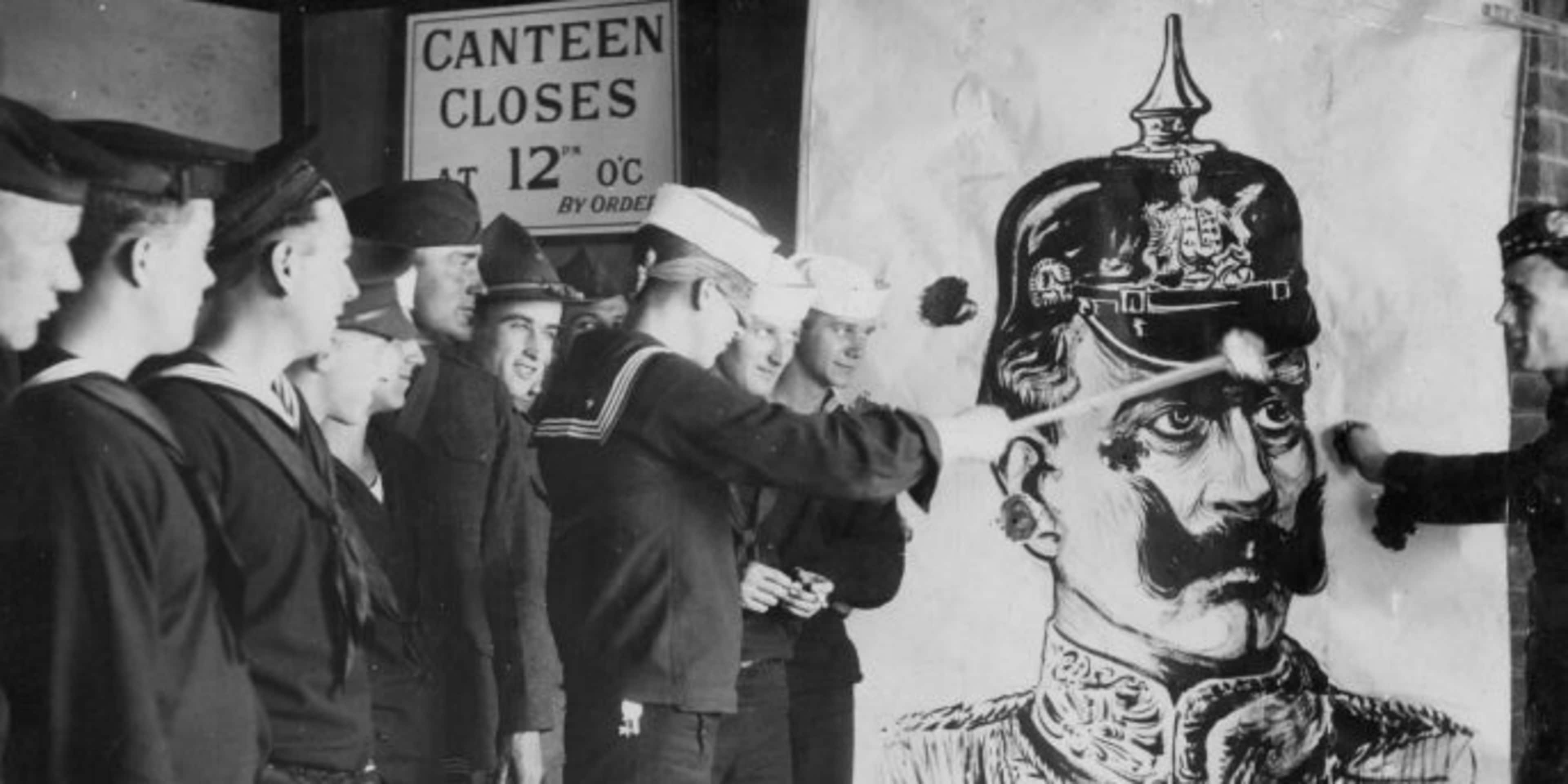 American troops throwing darts at a picture of the German Kaiser during World War One. (Credit: Paul Thompson/FPG/Archive Photos/Getty Images)