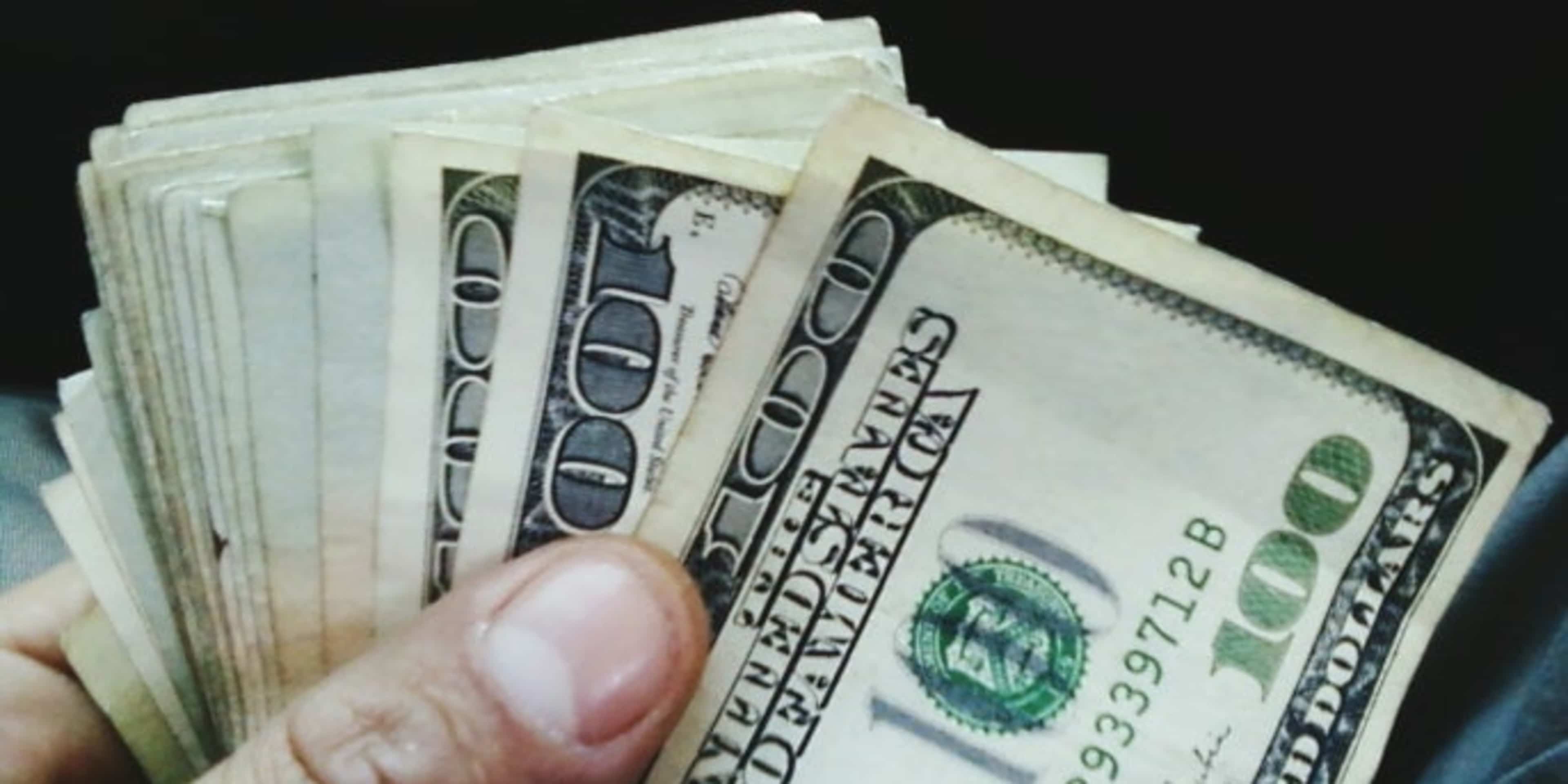Close-Up Of Hand Holding U.S. Banknotes. (Credit: Michael Trujillo/Getty Images)
