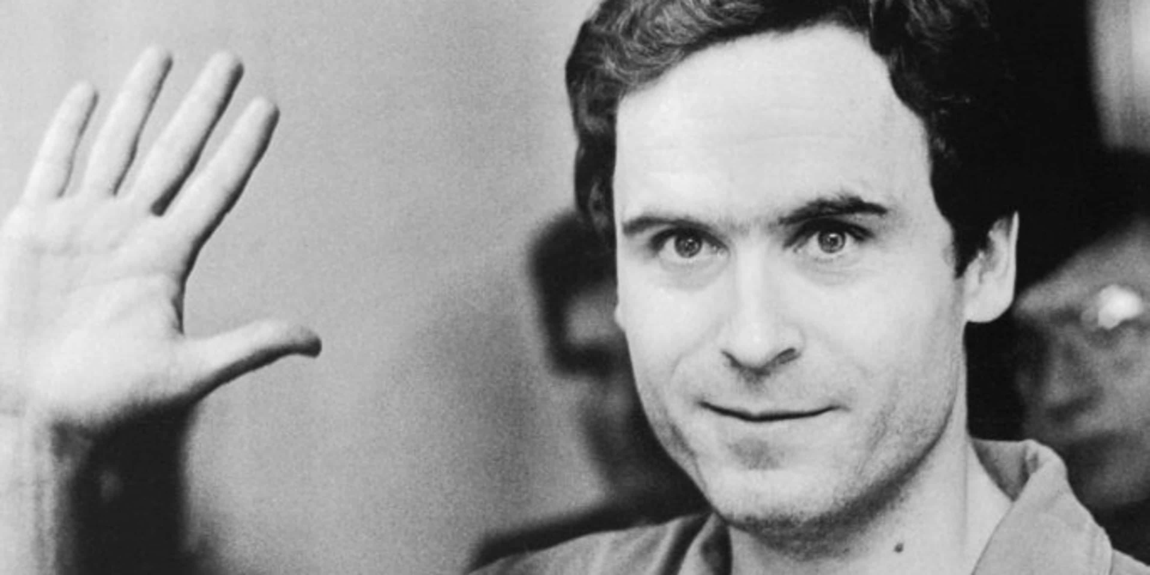 Serial Murderer Theodore "Ted" Bundy walks forward and waves to TV camera as his indictment for the January murders of Lisa Levy and Margaret Bowman is read at the Leon County Jail.