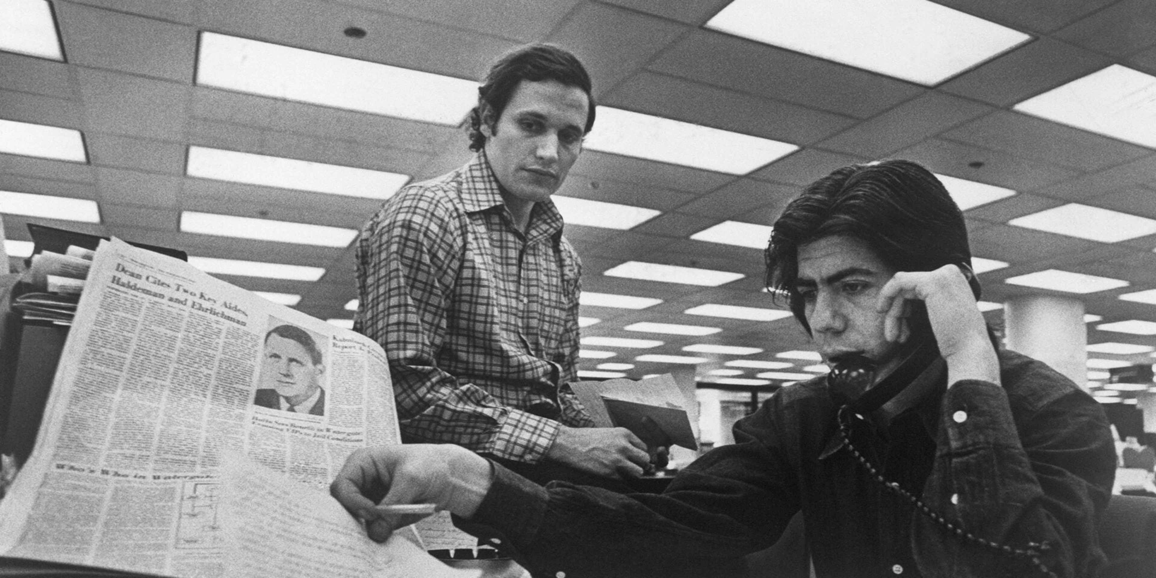 Bob Woodward (left) and Carl Bernstein, Washington Post staff writers who have been investigating the Watergate case, at their desk in the Post.