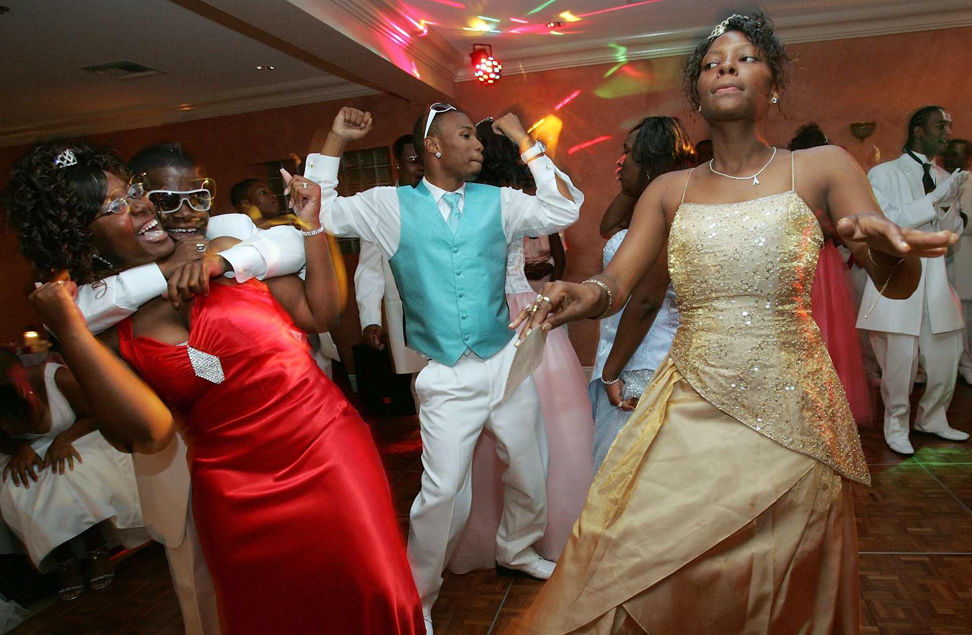 Teenagers dressed in colorful prom attire dancing