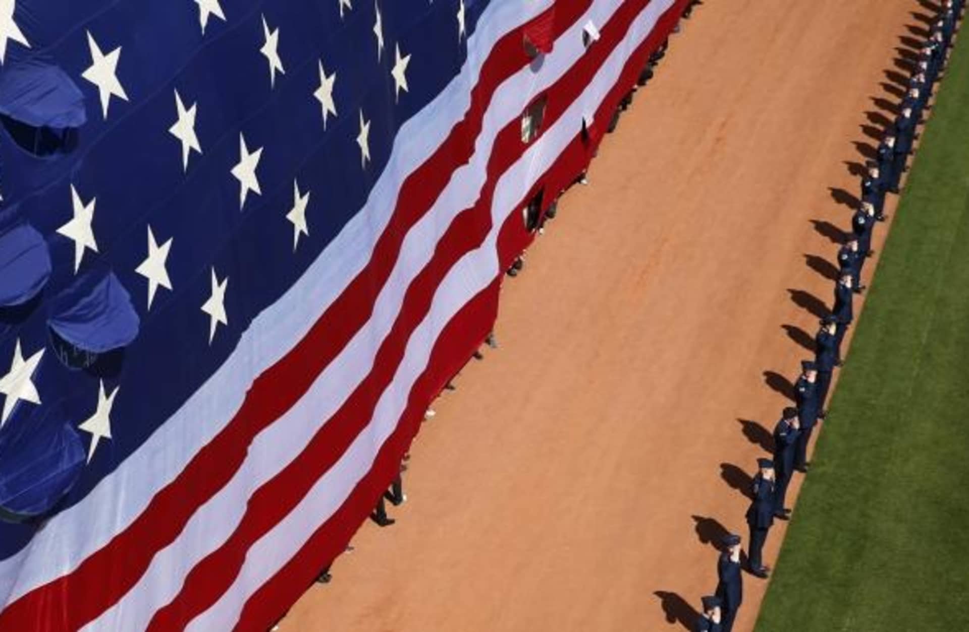 A giant flag lowered for the national anthem during the Red Sox home opener at Fenway Park in Boston, 2015. (Credit: Jessica Rinaldi/The Boston Globe via Getty Images)