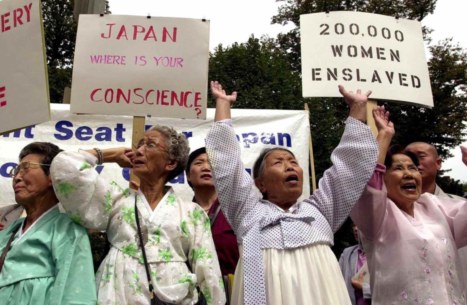 A group of women, who survived being forced into brothels set up by the Japanese military during World War II, protesting in front of the Japanese Embassy in 2000, demanding an apology for their enslavement. (Credit: Joyce Naltchayan/AFP/Getty Images)