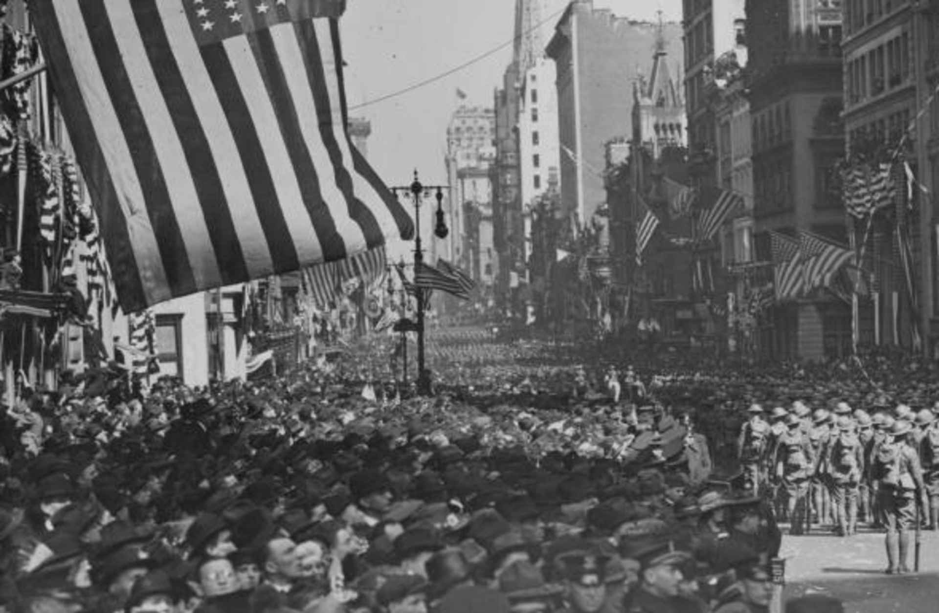A military parade with crowds of excited spectators along 5th Avenue, in celebration of Armistice day and peace in Europe following World War One, New York, 1918. (Photo by Paul Thompson/FPG/Getty Images)
