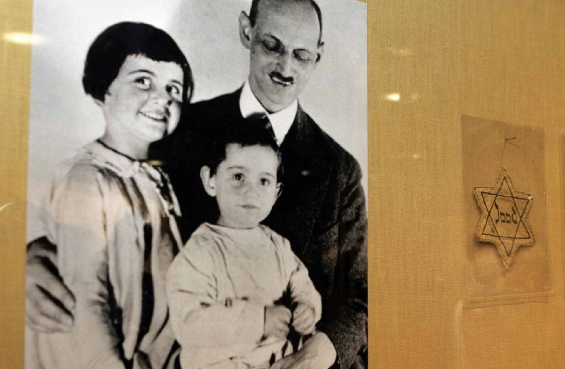 A photograph (left) of Otto Frank with his daughters Anne and Margaret; at right, yellow stars worn by Dutch Jews being displayed in New York, 2007.