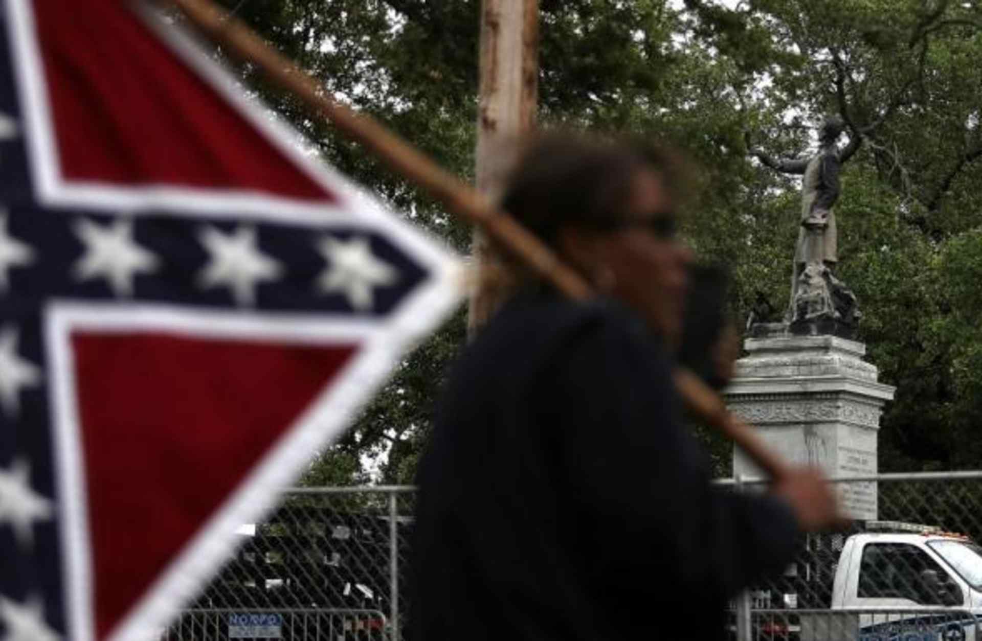 A protester holds a Confederate flag across the street from the Jefferson Davis monument on May 4, 2017.