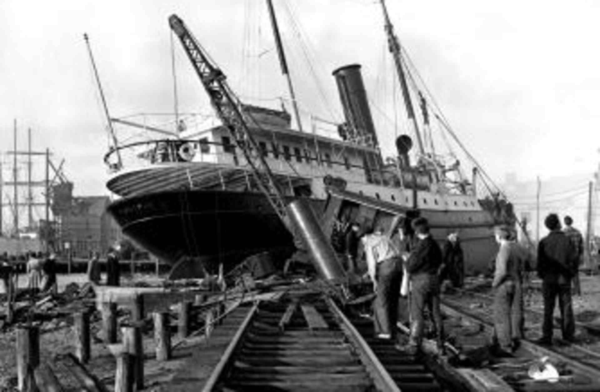 A ship uprooted from the water lays across railroad tracks in New London, Connecticut. (Credit: Getty Images)
