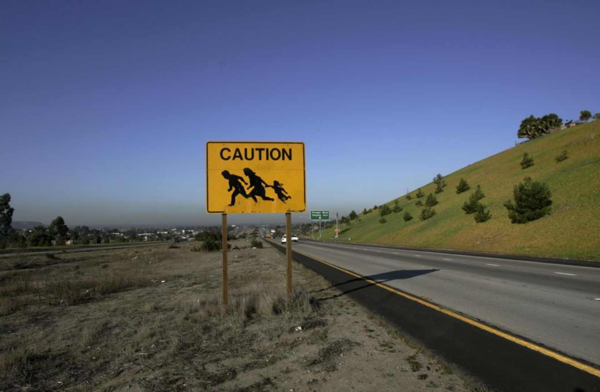 A sign is posted near the US and Mexico border warning drivers of immigrants crossing the freeway in San Ysidro, CA in 2006, just before the signing of the Secure Fence Act. (Credit: Hector Mata/AFP/Getty Images)