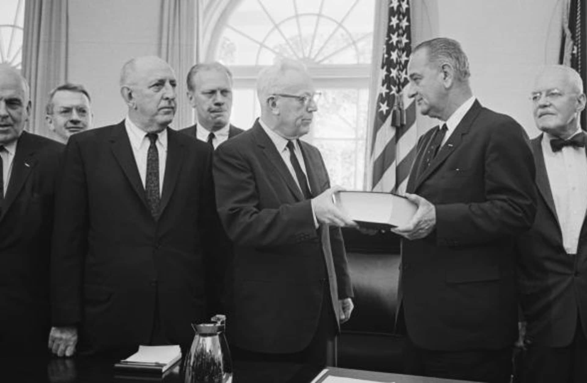Chief Justice Earl Warren hands over his report on the Kennedy assassination to President Johnson. The lengthy report, submitted on September 24, 1964, was composed by the seven-member panel who investigated the murder. (Credit: Bettmann/Getty Images)