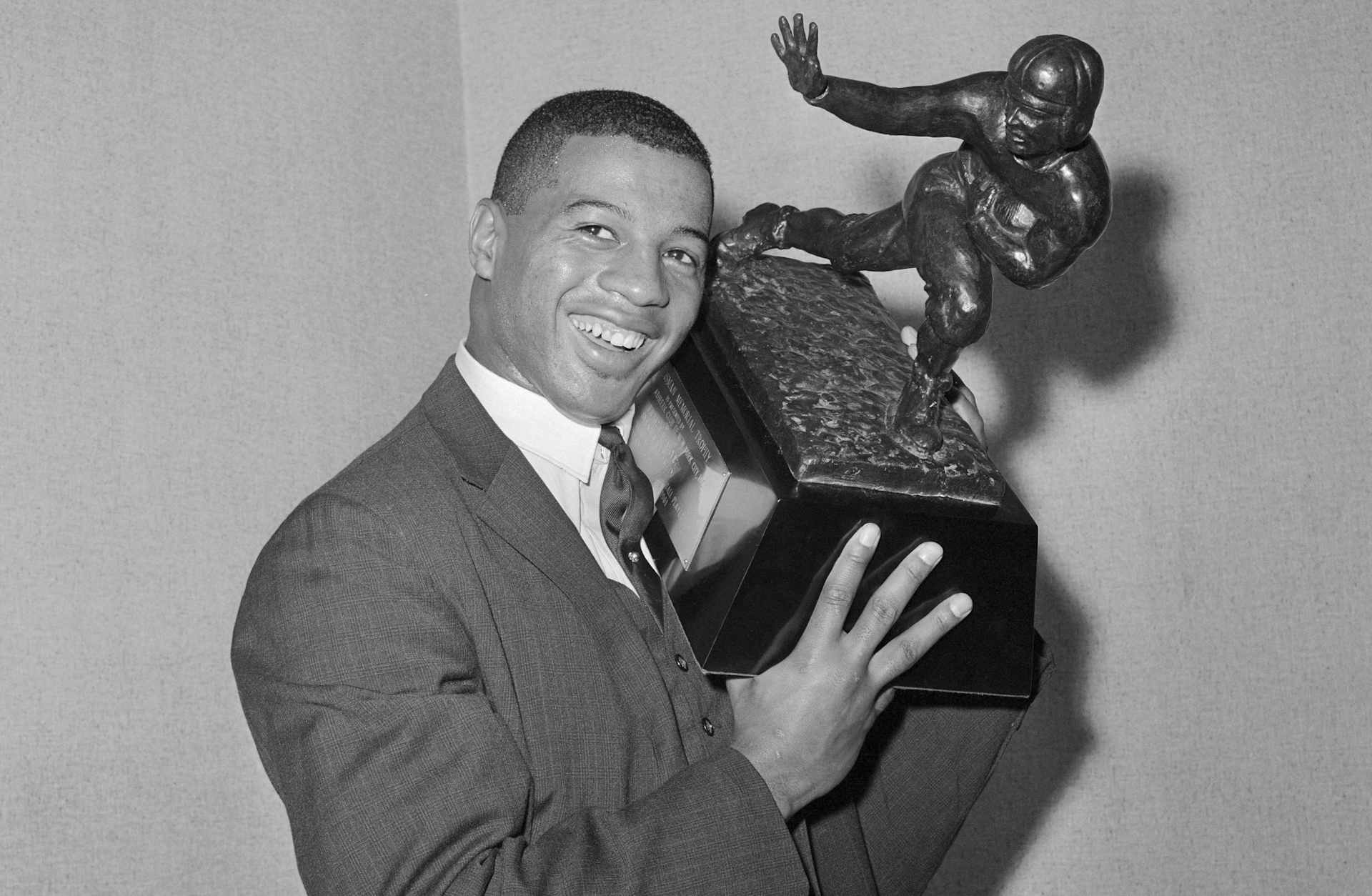 Winner of Heisman Trophy. New York, New York: Syracuse University halfback, Ernie Davis, proudly holds the 1961 Heisman Trophy which he was awarded here, December 6, as the outstanding college football player of the United States for 1961. Some 840 sportscasters and writers across the country selected Davis for the honor.
