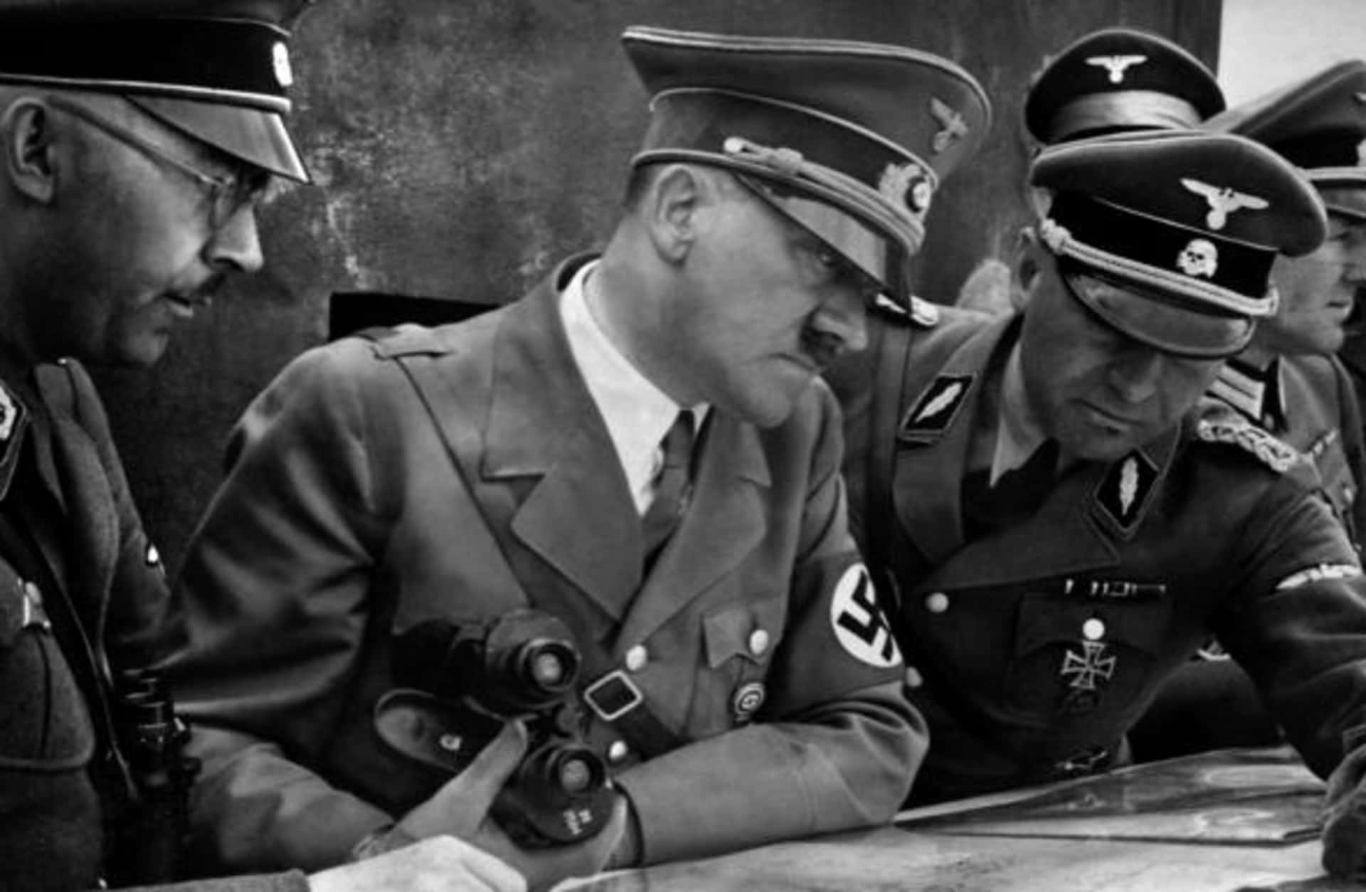 German Nazi Chancellor and dictator Adolf Hitler consulting a geographical survey map with his general staff including Heinrich Himmler and Martin Bormann duringWorld War II, 1939. (Credit: France Presse Voir/AFP/Getty Images)