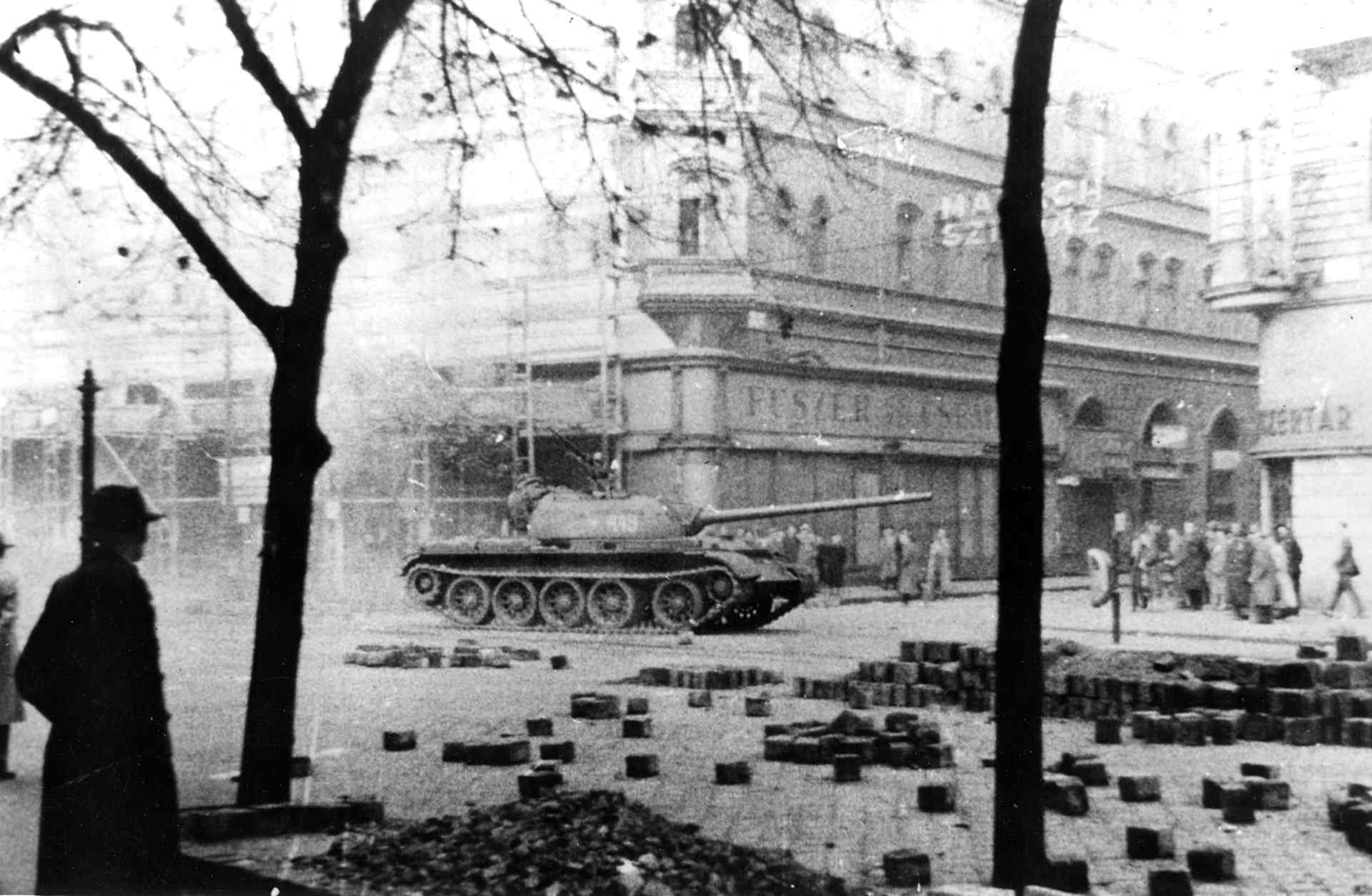 View of Russian Army tank as it patrols past pedestrians during the Hungarian Revolution, Budapest, Hungary, November 1956.