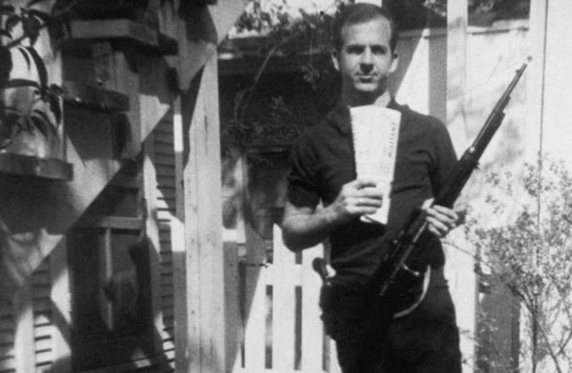 Lee Harvey Oswald holds a Mannlicher-Carcano rifle and newspapers in a backyard. This is one of the controversial photos used in the investigation of the assassination of John F. Kennedy in 1963. (Credit: Corbis via Getty Images)