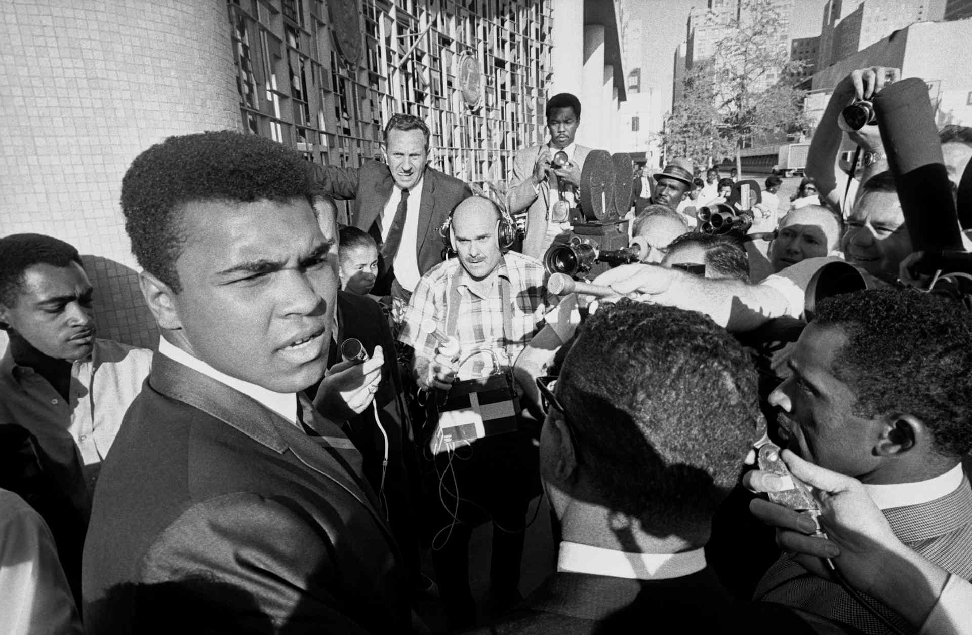 Former world heavyweight boxing champion Muhammad Ali (L) is surrounded by journalists as he leaves the federal court after a jury found him guilty on charges of refusing to be inducted into the U.S. armed forces. Clay contended that he was a Nation of Islam minister and not subject to the draft.