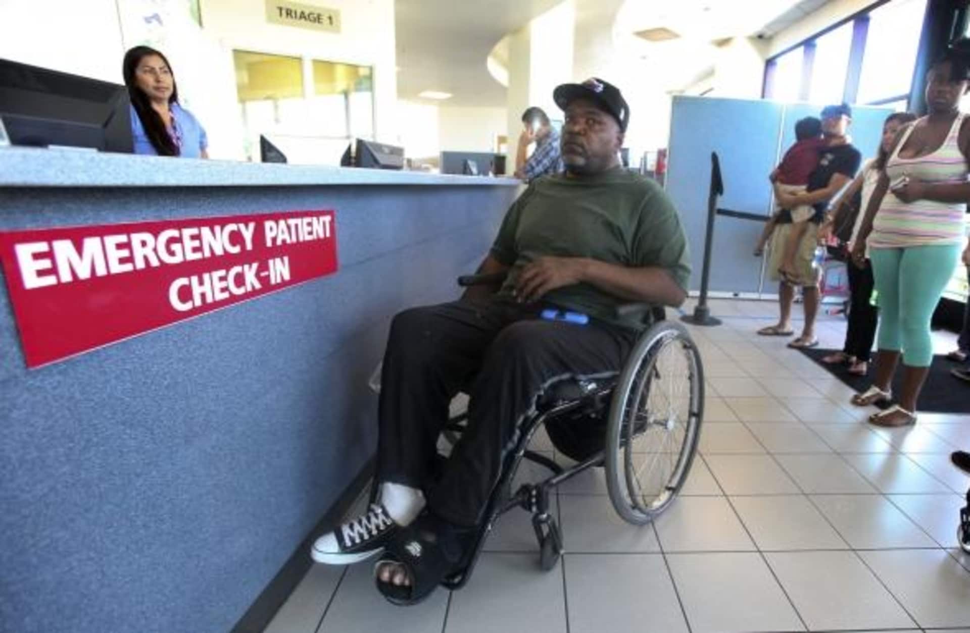 Nikita Hendrix (in wheelchair) waits to be treated for a pressure sore on his foot, during a visit to the emergency room at Long Beach Memorial Hospital, 2014.  In one of the first signs of the effects of Obamacare, most hospitals in Los Angeles County had an increase in visits to their emergency departments in the first part of 2014.