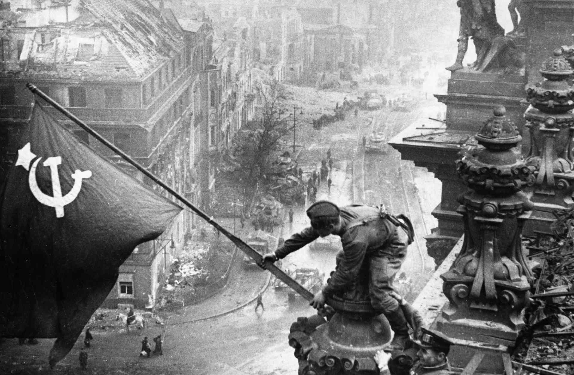 The famous photo of Soviet soldiers over Reichstag during the Battle of Berlin, which was later revealed to be staged and altered.