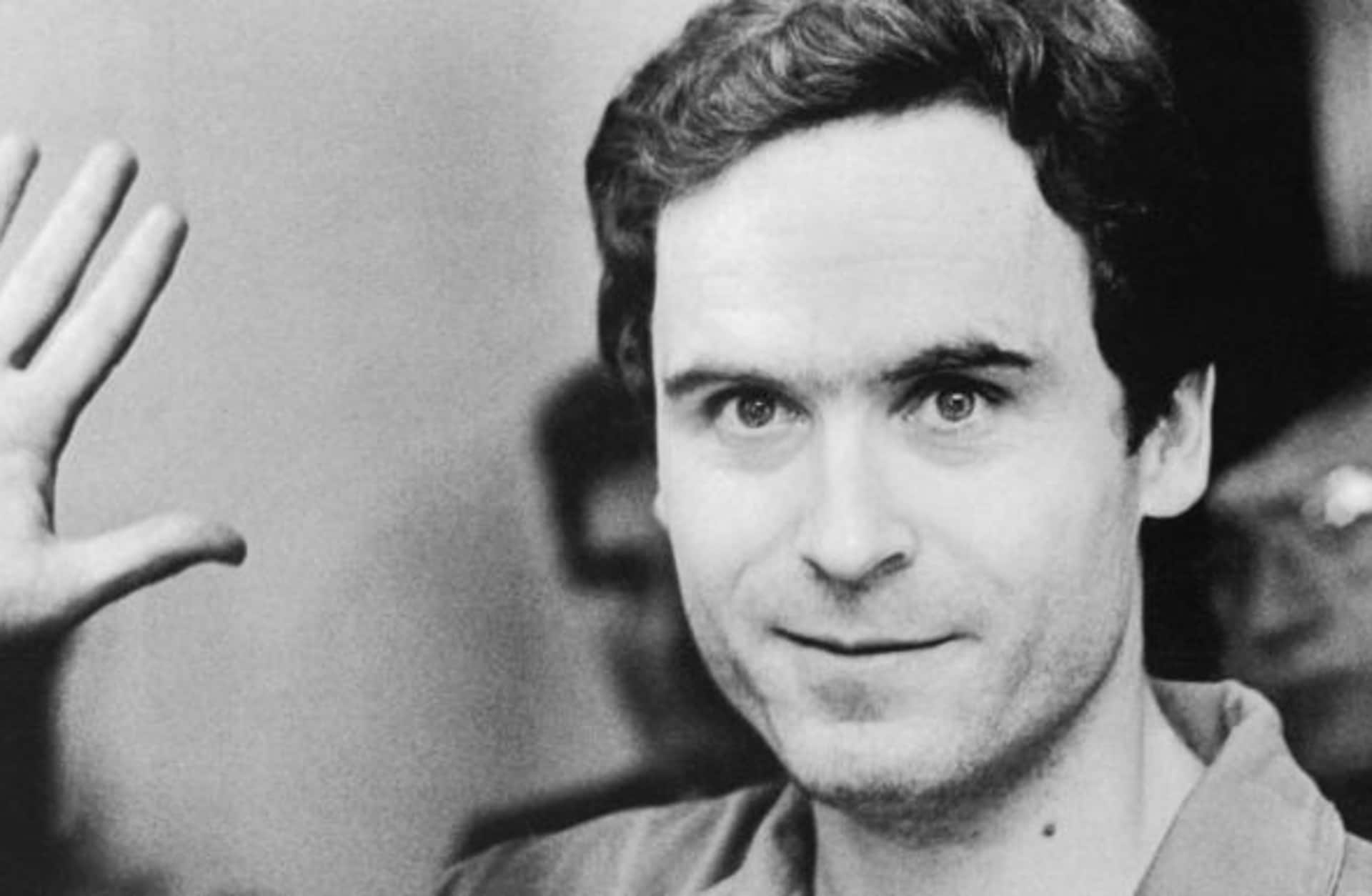 Serial Murderer Theodore "Ted" Bundy walks forward and waves to TV camera as his indictment for the January murders of Lisa Levy and Margaret Bowman is read at the Leon County Jail.