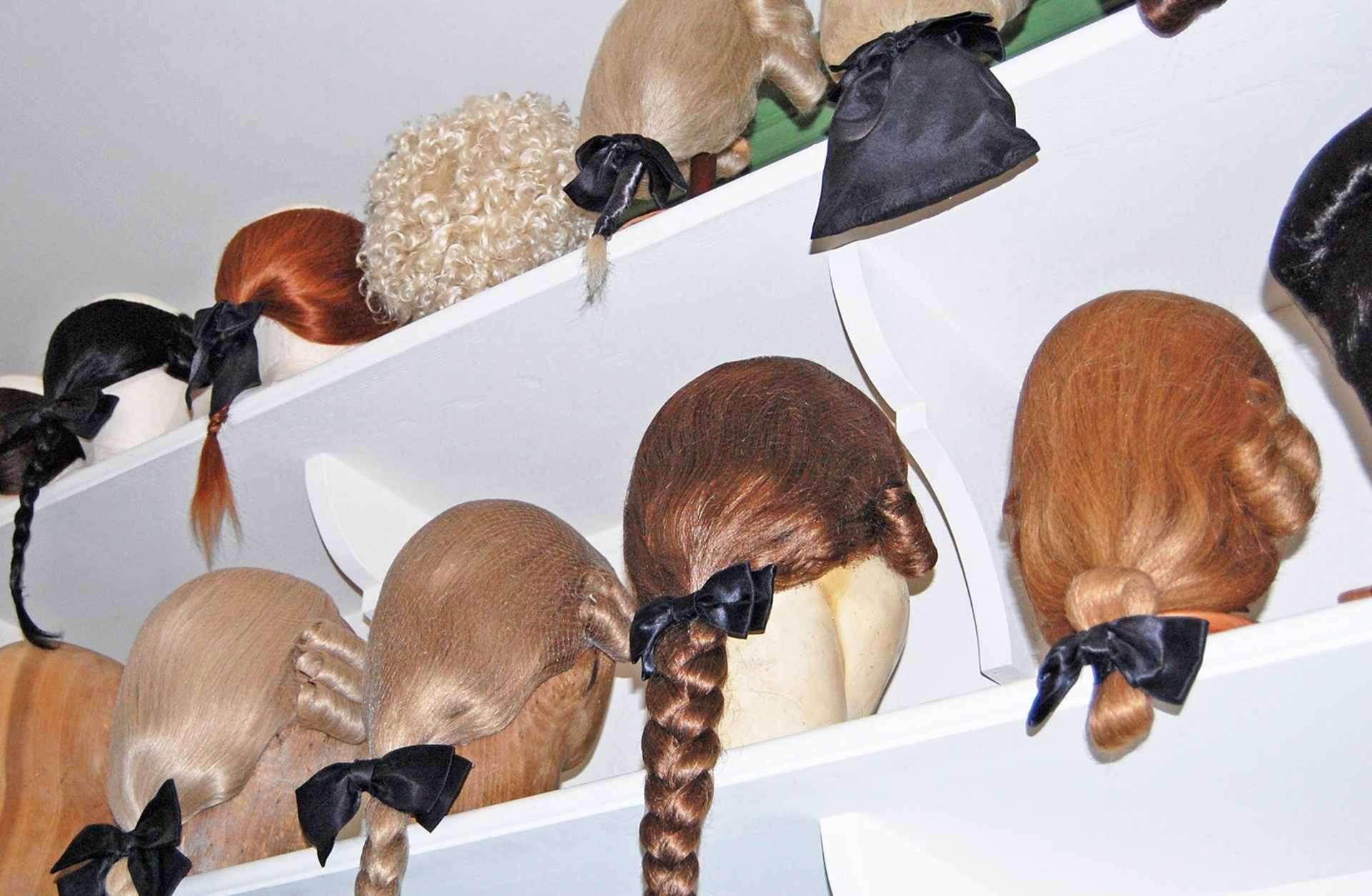 Costume wigs modeled on those worn in the American colonies.