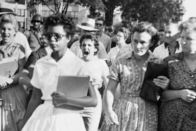 An alternate-angle view of Elizabeth Eckford on her first day of school, taken by an Associated Press photographer. Hazel Bryan can be seen behind her in the crowd.