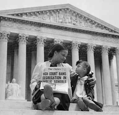 Nettie Hunt explaining to her daughter Nickie the meaning of the high court's ruling in the Brown v. Board of Education case on the steps of the U.S. Supreme Court. (Credit: Bettmann Archive/Getty Images)