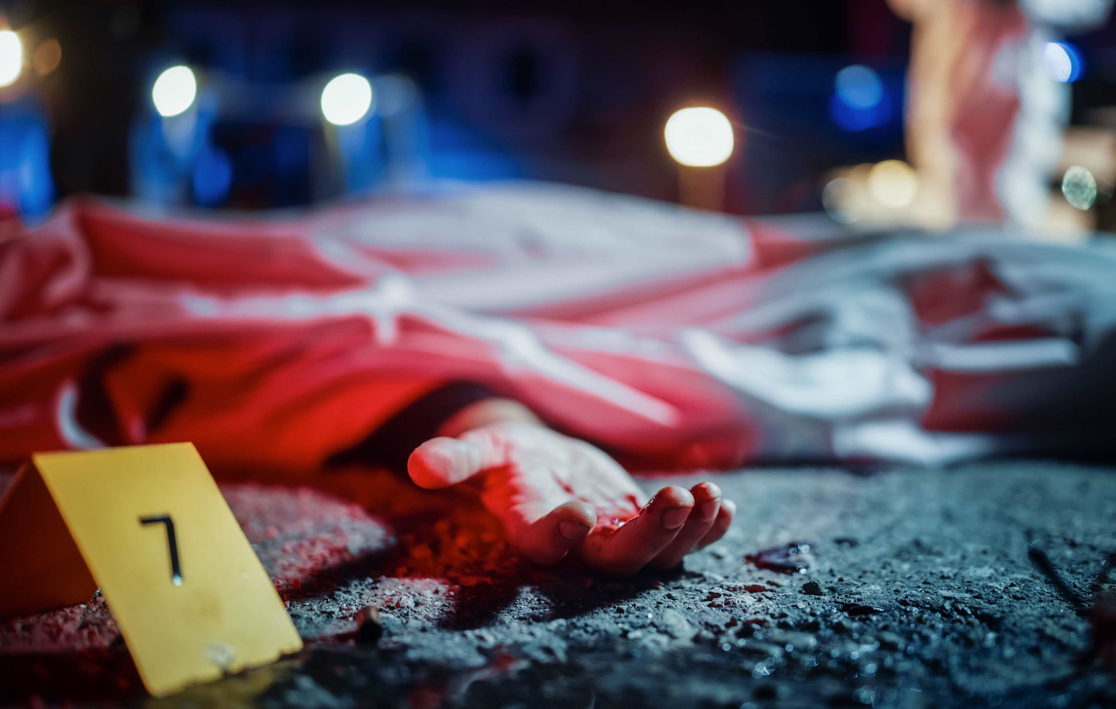 Close Up Low Angle: A Corpse with a Bloody Hand Lying on the Floor and Covered. Gruesome Murder Case Leaving Victim for Dead. Forensics Taking Photos Before Body is Taken to Morgue. Cinematic Shot