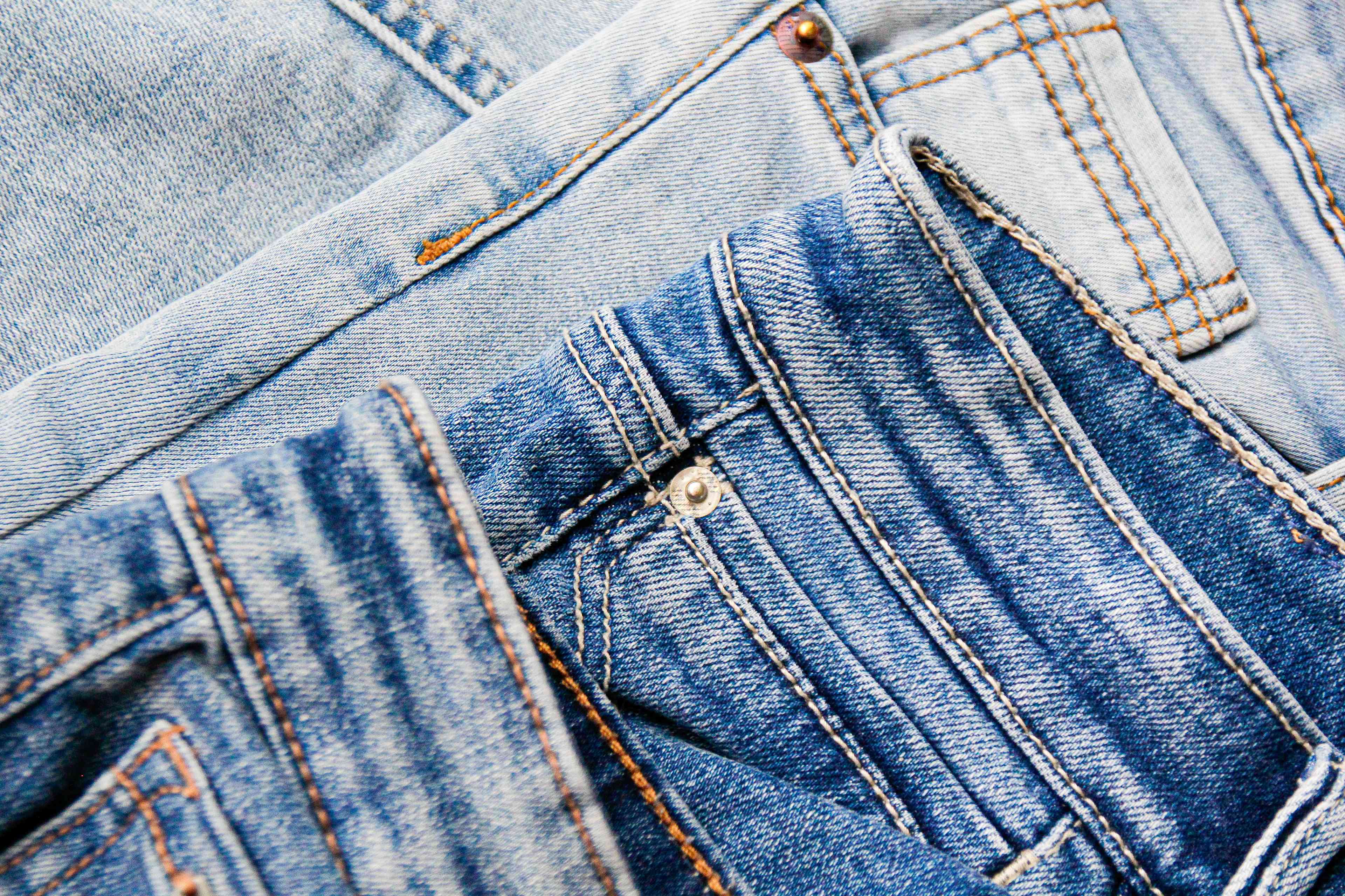 a pile of three pairs of folded jeans