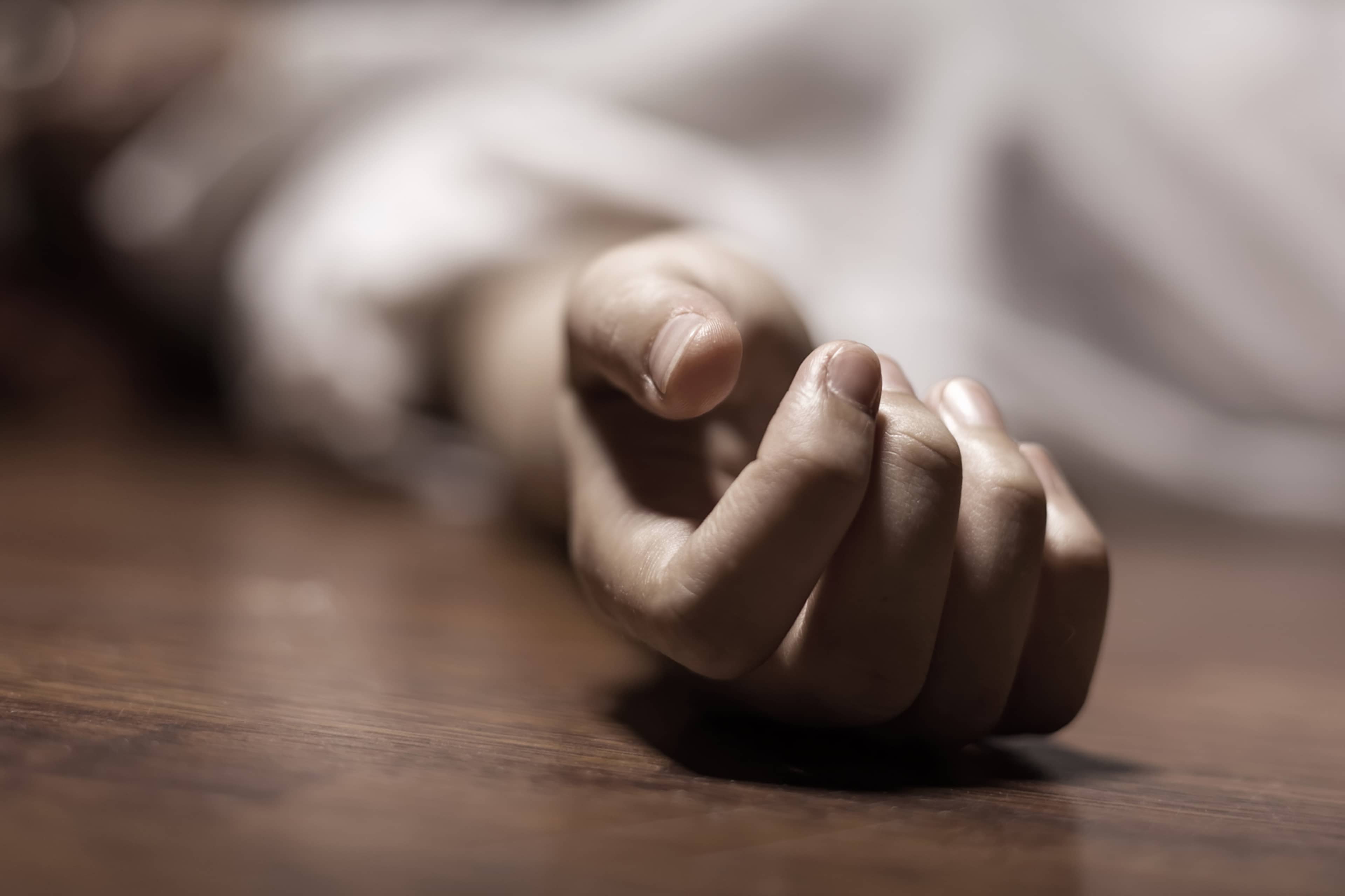 Delicate, pale hands resting on a wooden surface, creating a serene and contemplative atmosphere.