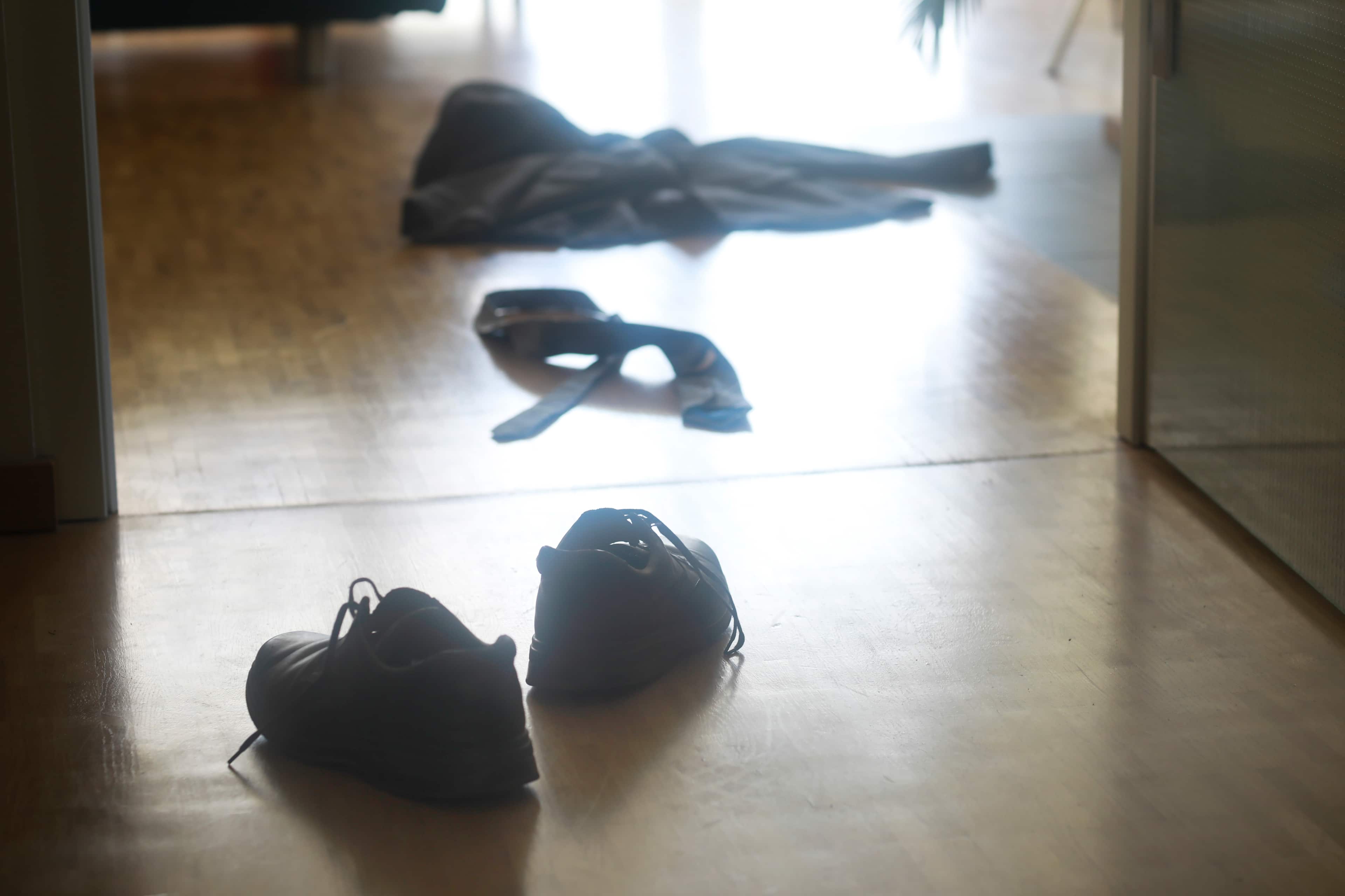 Shoes, jacket and tie on the floor in the hallway