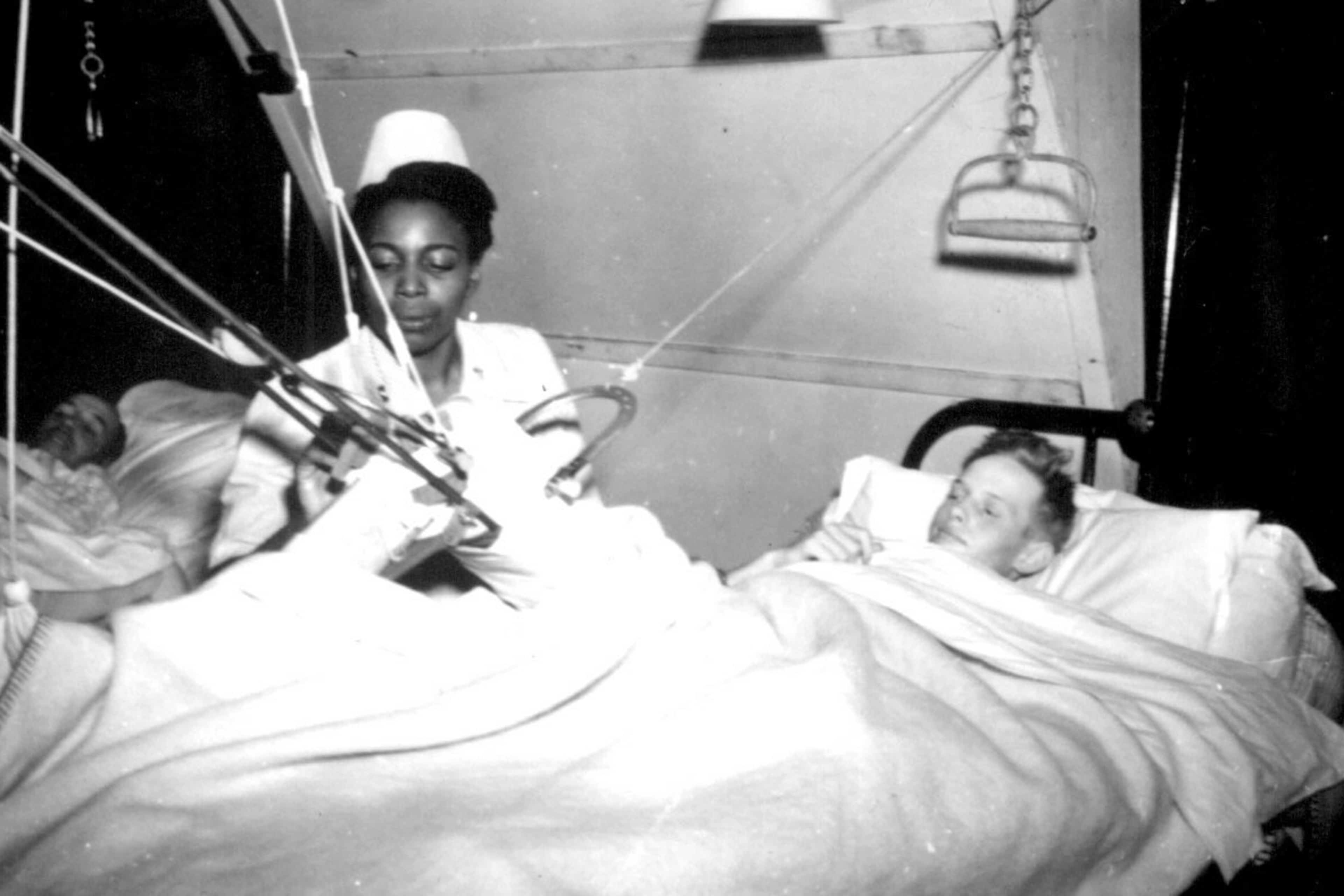 Lt. Florie E. Grant tending to a patient at a prisoner of war hospital, 1944