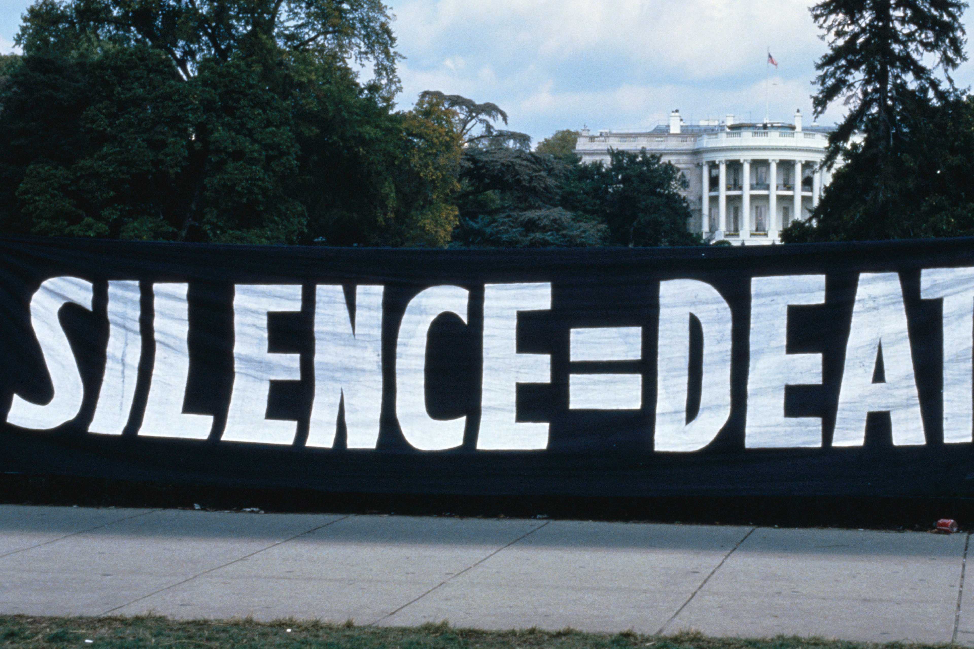ACT UP activists hang a "silence = death" banner on the White House gates in 1992.