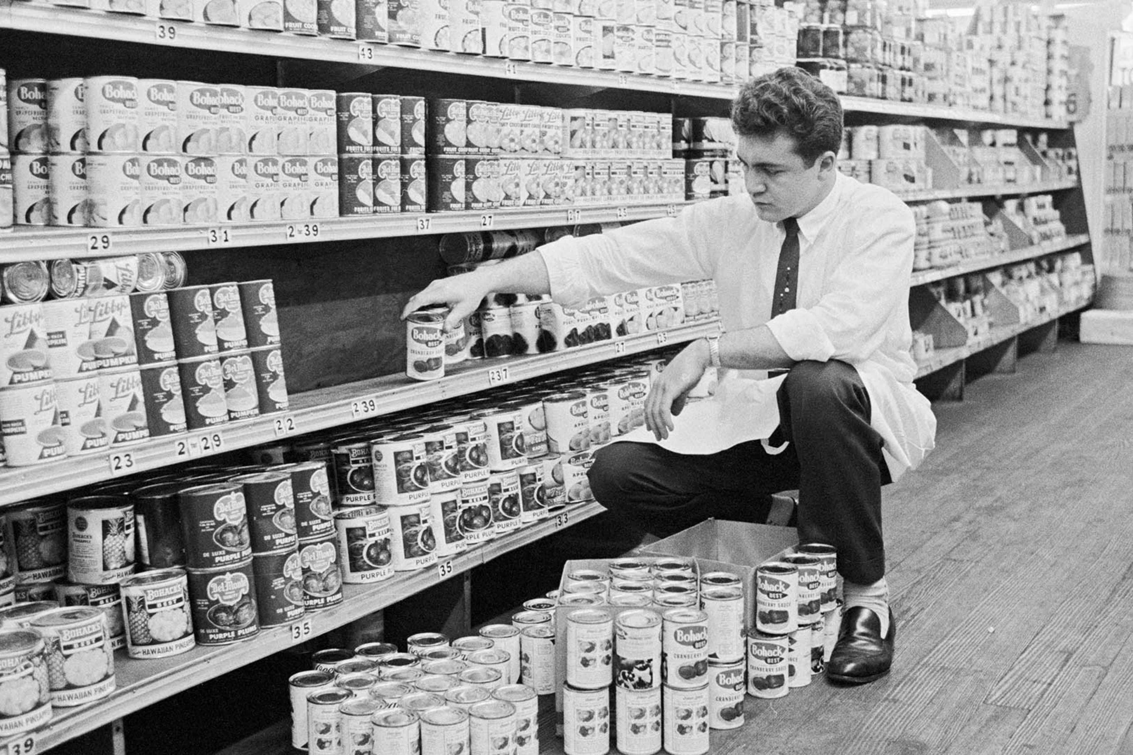 A clerk removes cans of cranberry from the shelves in a supermarket in Jackson Heights, Queens, Nov. 10, 1959.