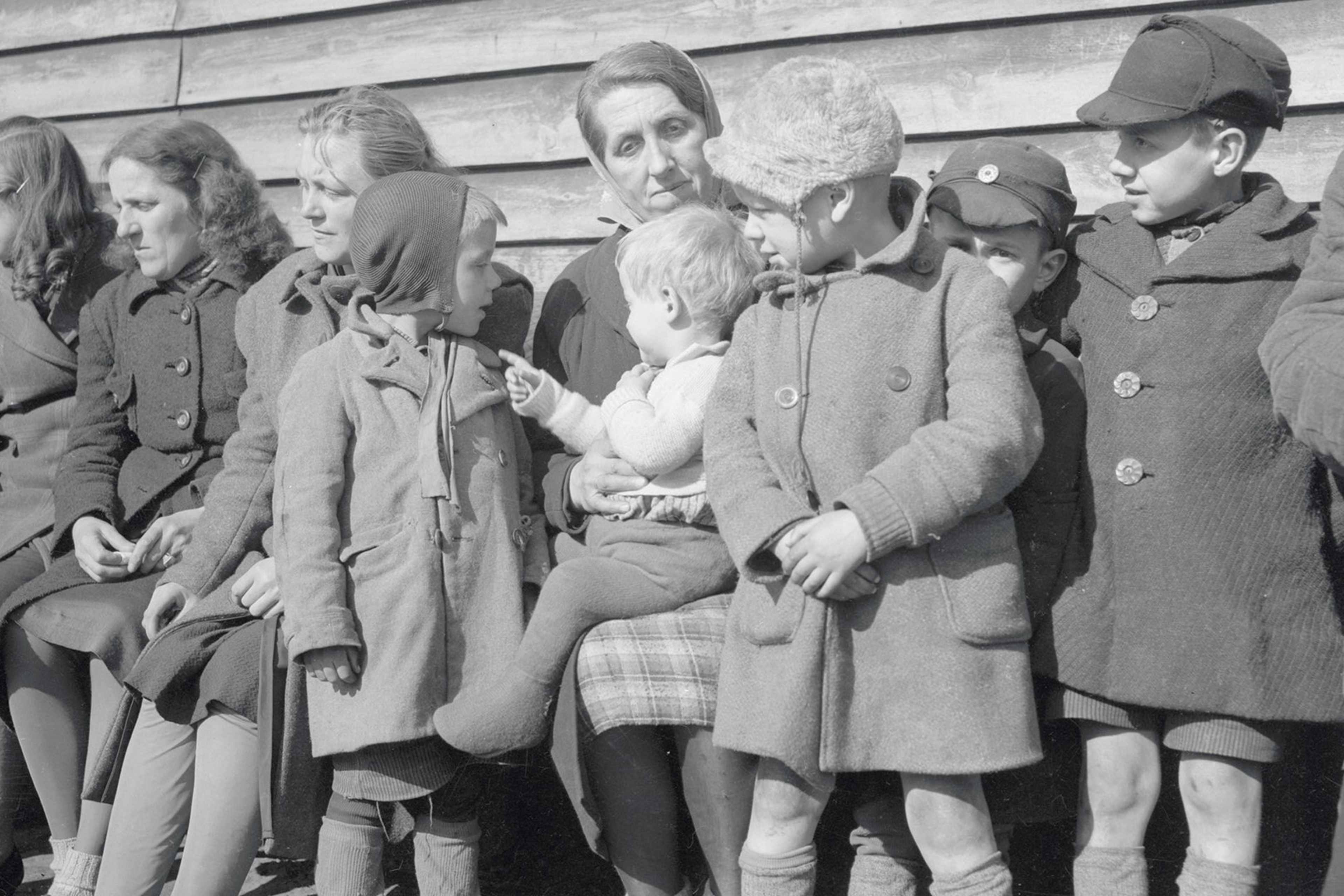 A mother sits with five of her children at a Displaced Persons Camp in Europe.