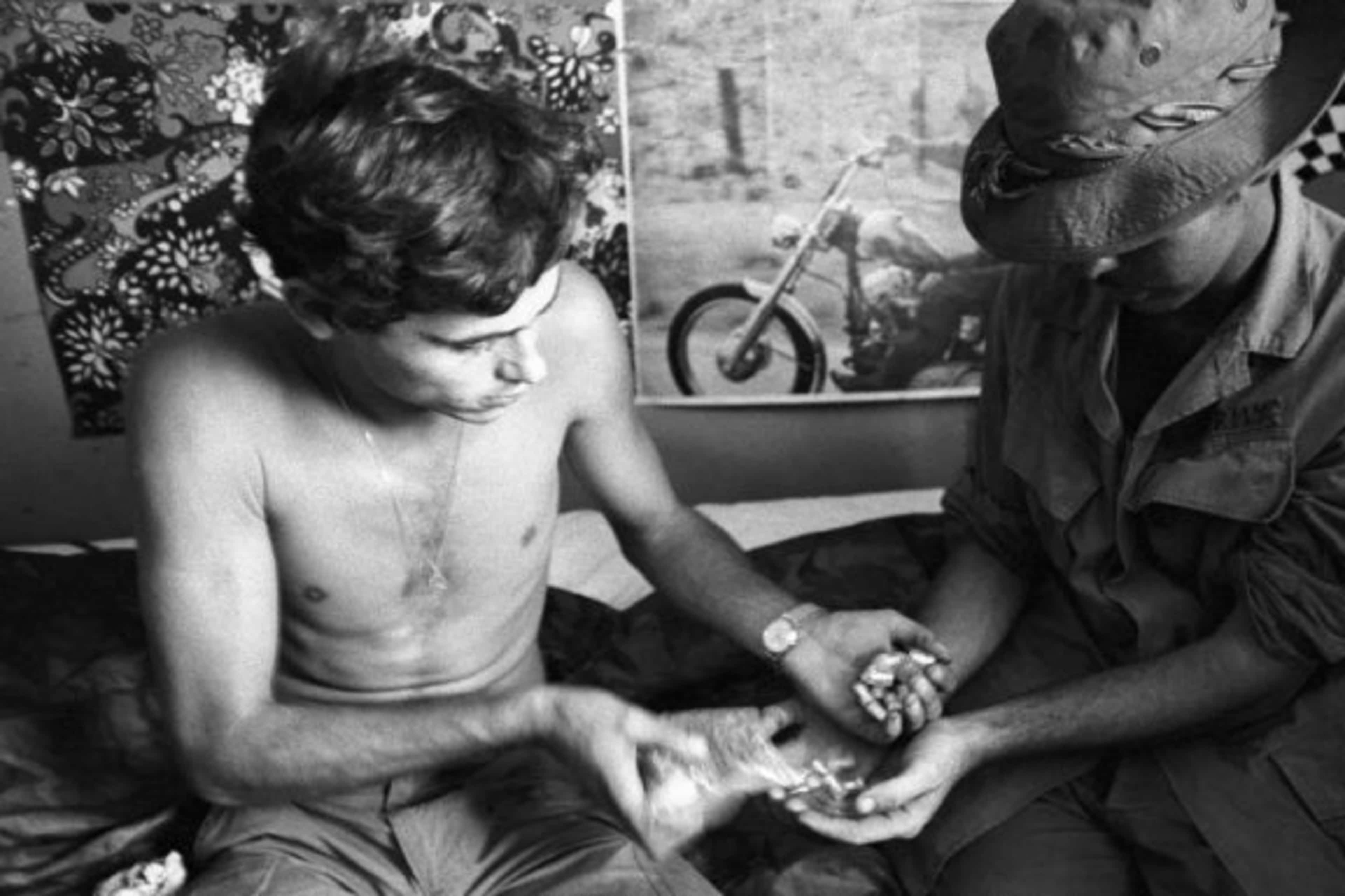 Two U.S. soldiers in Vietnam exchanging vials of heroin. (Credit: Bettmann Archive/Getty Images)