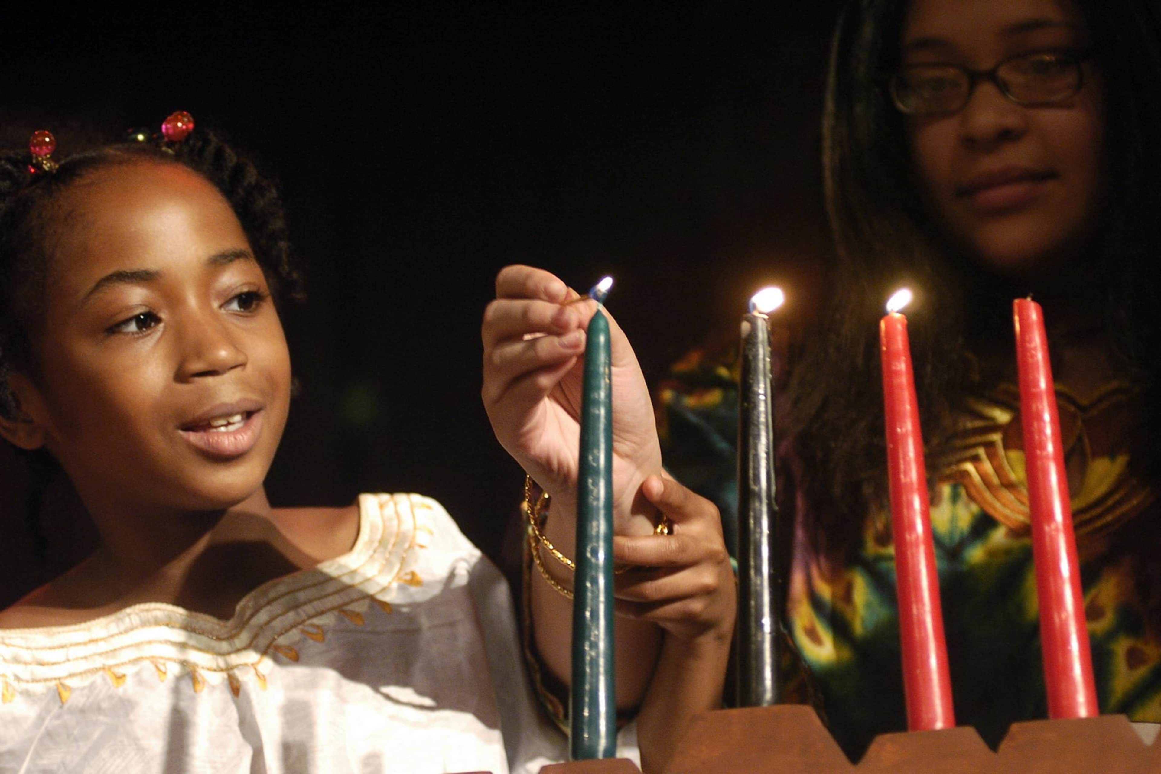 Brooklyn students light a candle celebrating Ujamaa (CooperaUNITED STATES - DECEMBER 29: Brooklyn students light a candle celebrating Ujamaa (Cooperative Economics), one of the Seven Principles of Kwanzaa, during a celebration at the American Museum of Natural History. The celebration kicks off the Museum's 2005 Kwanzaa festival, which will take place Dec. 29-31. (Photo by Linda Rosier/NY Daily News Archive via Getty Images)