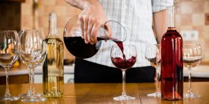 Different Kinds of Wine Being Decanted and Poured into Wine Glasses