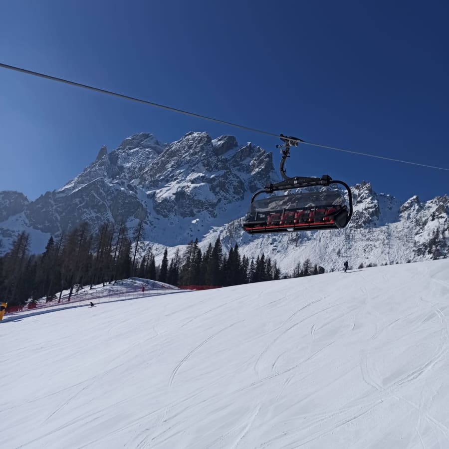 Una seggiovia sopra le piste innevate, con le montagne sullo sfondo