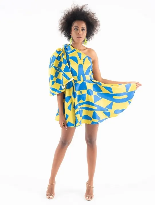 Model wearing Imprint’s blue and yellow one shoulder dress with a puff sleeve. It’s a statement making dress if you are thinking of festival outfit ideas. Made in South Africa.