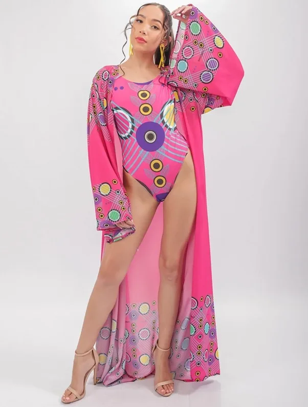 Model wearing FabroSanz pink print kimono with one-piece swimsuit. Made in South Africa. This is great to wear with pants or pair of skimpy festival-appropriate shorts. Perfect for when you are looking for festival outfit ideas.