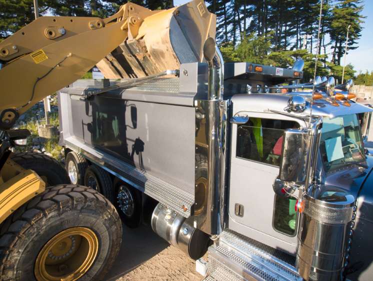 Close-up of Loading topsoil into a dump truck