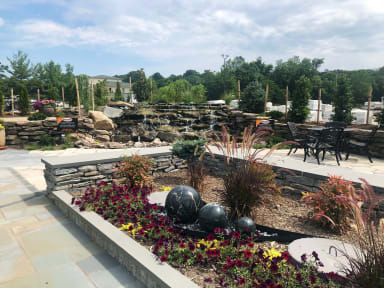 Outdoor display with waterfall and retaining wall