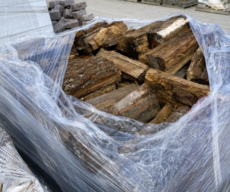 Firewood shrinkwrapped and palletized, opened to show wood pieces