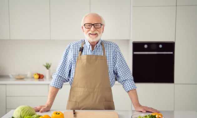 personne agée souriante dans sa cuisine