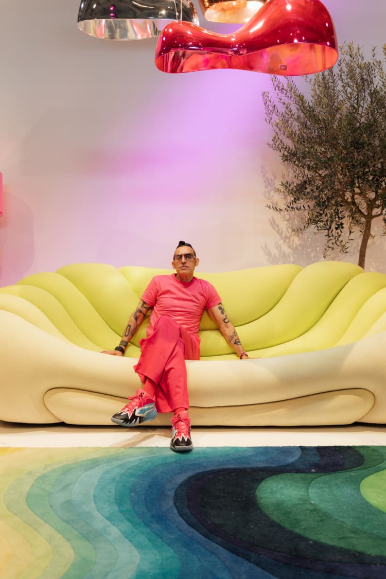 Karim Rashid a KARE berlini szalonjában, a Dreamscape Sunrise kanapén. A bútor a a 2025-ös Fluid Realities kollekció része, a KARE és a dizájner közötti exkluzív együttműködés eredménye (forrás: Karim Rashid)